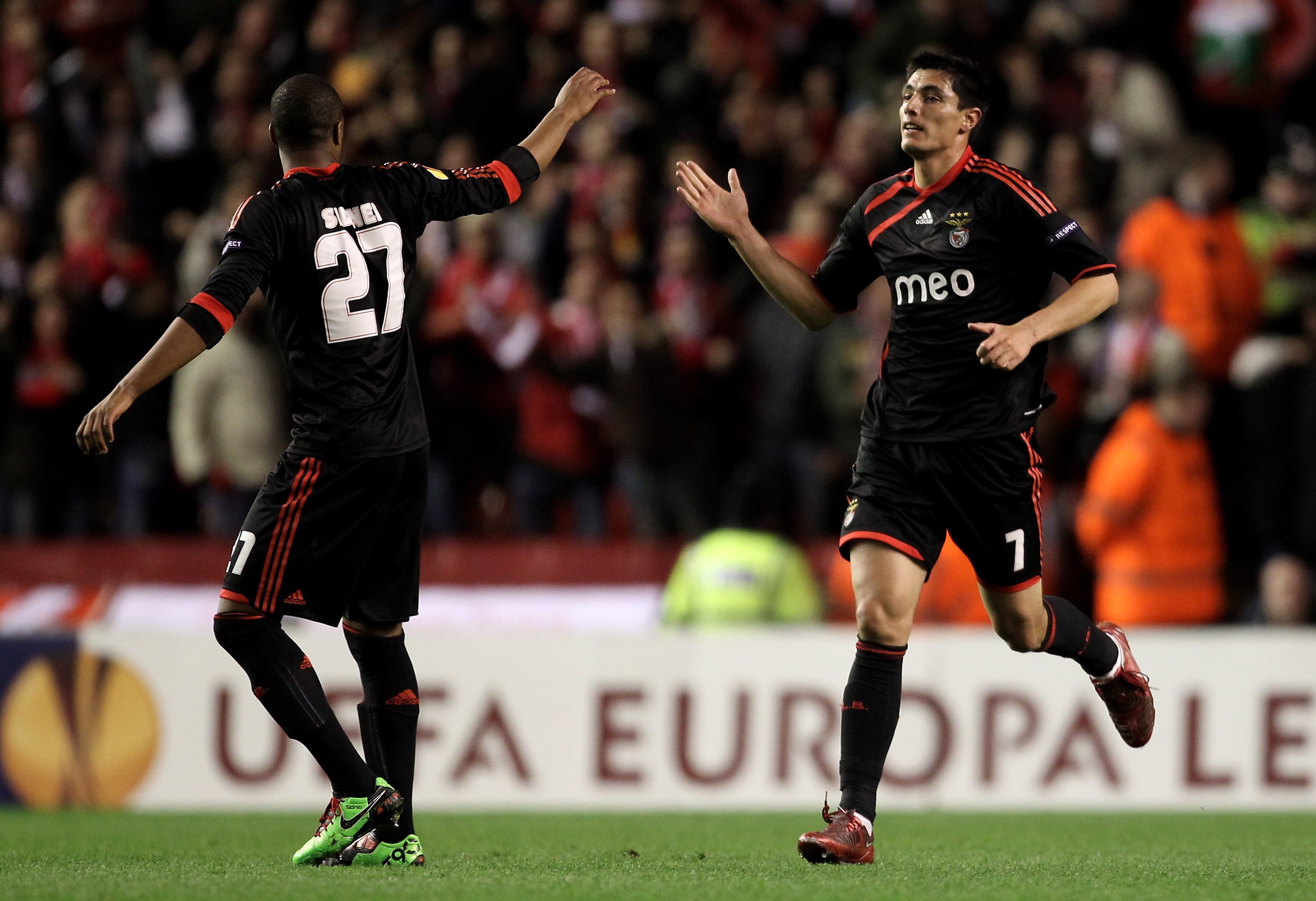 LIVERPOOL, ENGLAND - APRIL 08:  Oscar Cardozo of Benfica celebrates scoring his team's first goal with team mate Sidnei (L) during the UEFA Europa League Quarter Final second leg match between Liverpool and Benfica at Anfield on April 8, 2010 in Liverpool