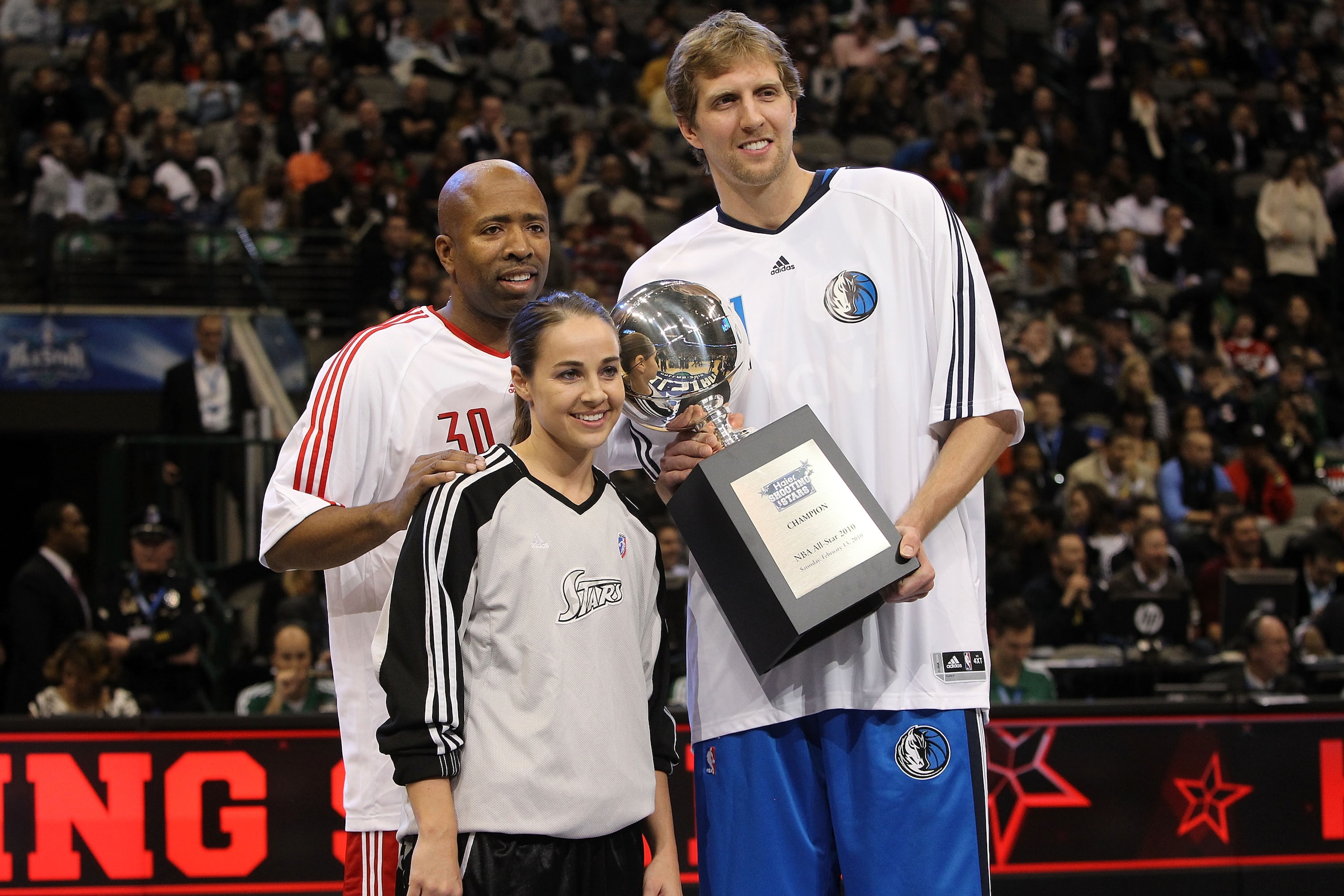DALLAS - FEBRUARY 13:  TNT analyst Kenny Smith #30 formerly of the Houston Rockets, Becky Hammon #25 and Dirk Nowitzki #41 of the Dallas Mavericks, all of team Texas, hold the Champions Trophy after winning the Haier Shooting Stars Competition on All-Star