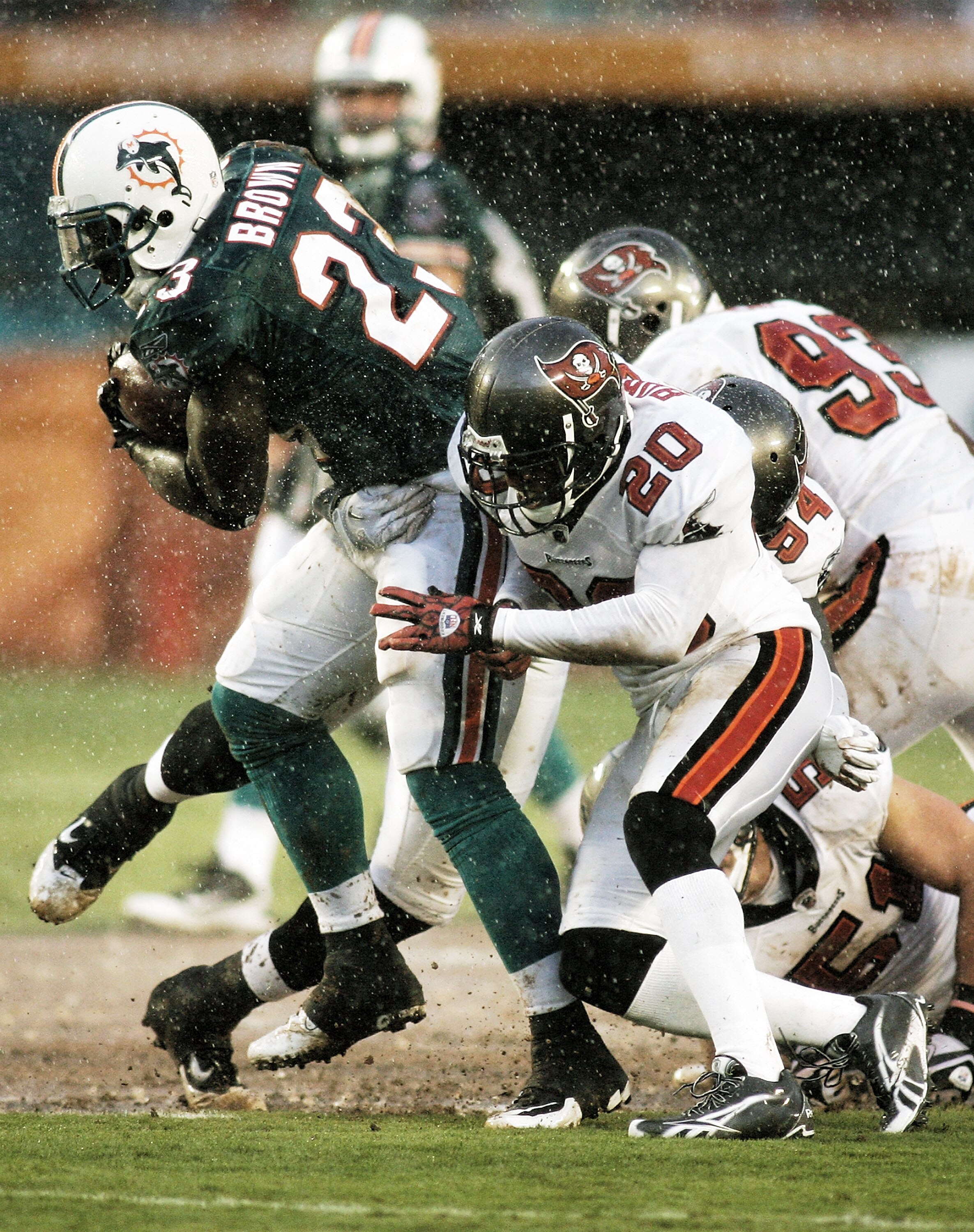 MIAMI - AUGUST 14:  Running back Ronnie Brown #23 of the Miami Dolphins (L) rushes against Cornerback Ronde Barber #20 of the Tampa Bay Buccaneers during the preseason game at Sun Life Stadium on August 14, 2010 in Miami, Florida.  (Photo by Marc Serota/G