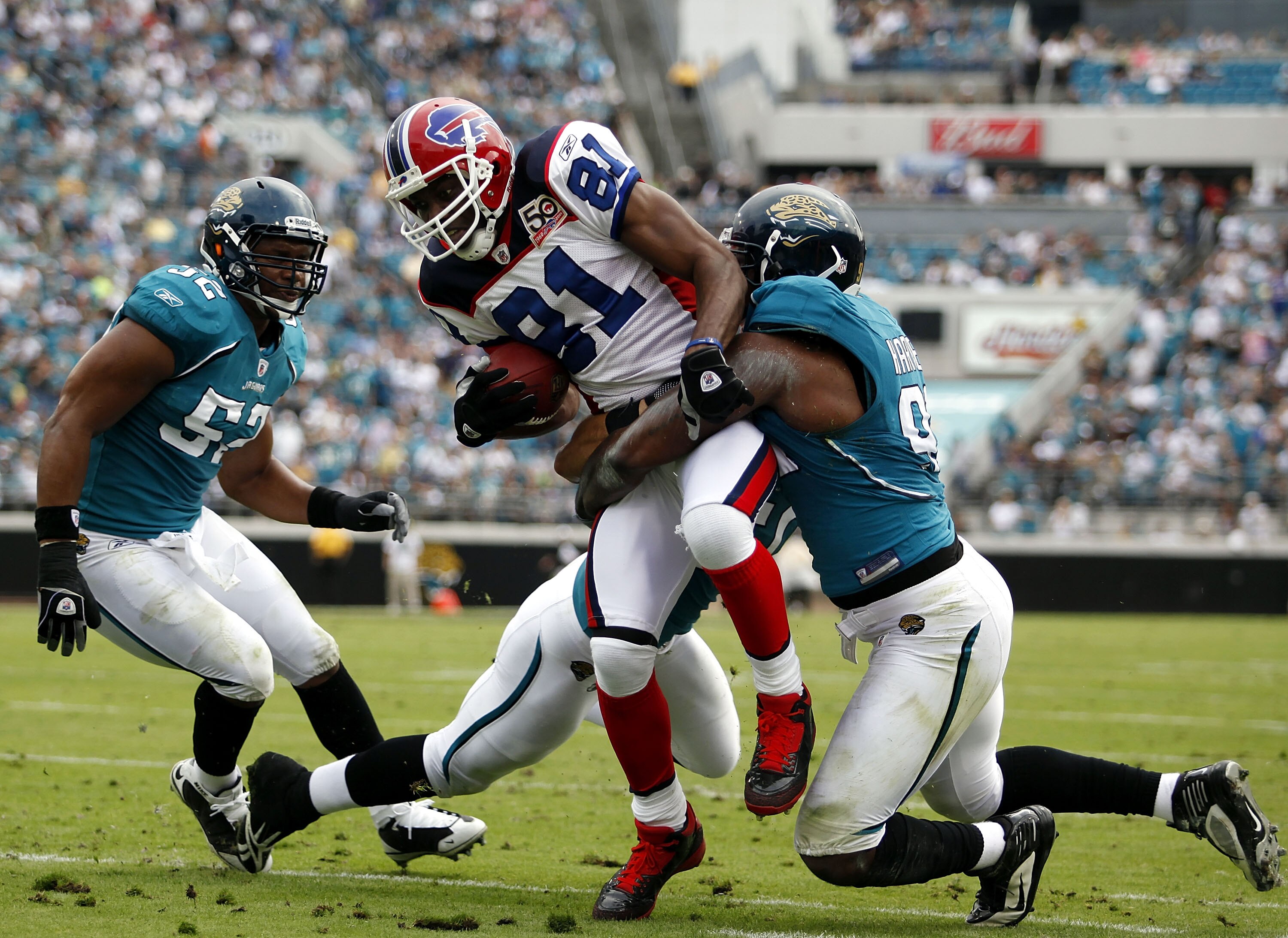 JACKSONVILLE, FL - NOVEMBER 22: Reciever Terrell Owens #81 of the Buffalo Bills is brought down by Jacksonville Jaguars defender Derrick Harvey #91 at Jacksonville Municipal Stadium on November 22, 2009 in Jacksonville, Florida.  (Photo by Marc Serota/Get