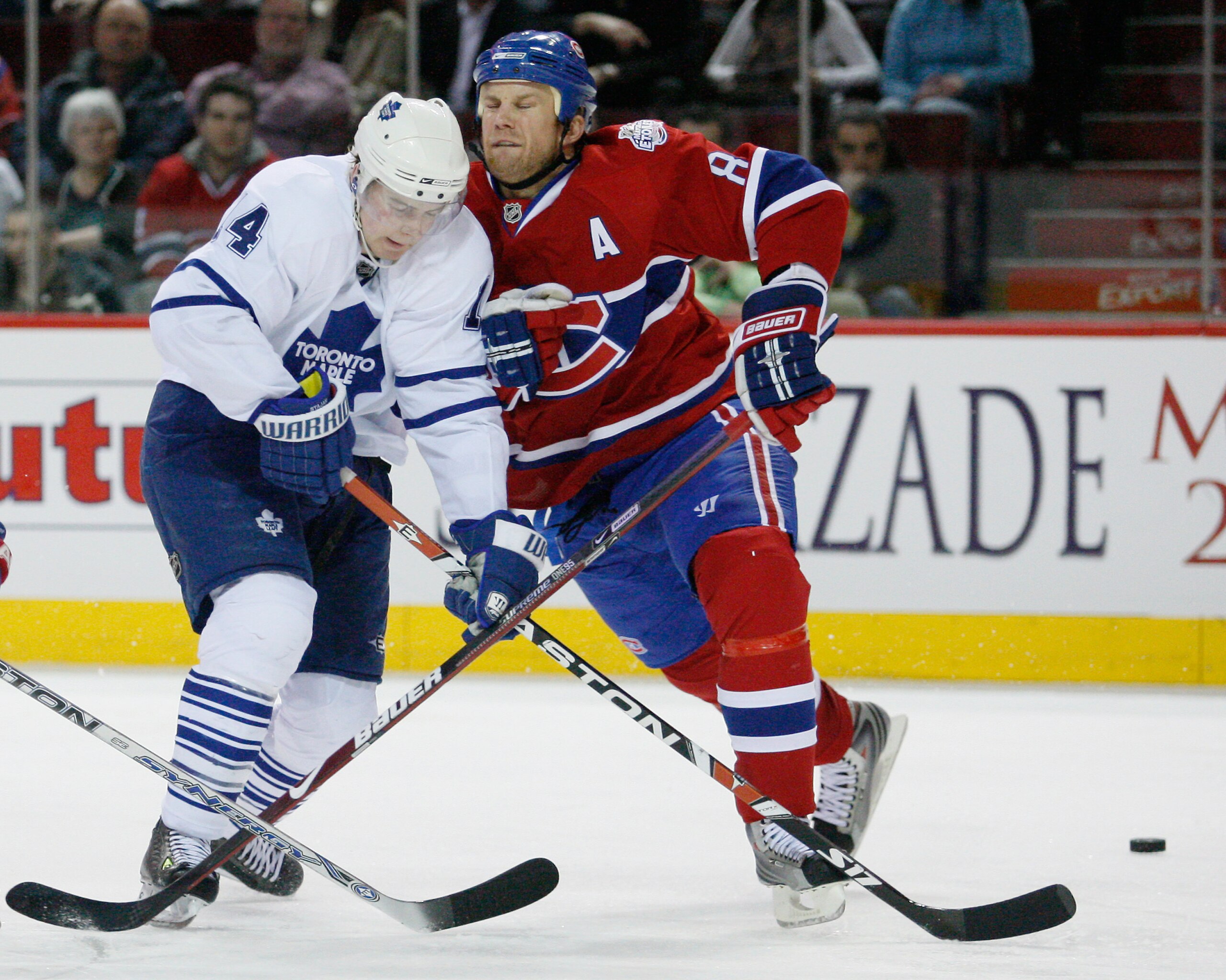 MONTREAL- JANUARY 8:  Mike Komisarek #8 of the Montreal Canadiens body checks Matt Stajan #14 of the Toronto Maple Leafs at the Bell Centre on January 08, 2009 in Montreal, Quebec, Canada.   The Montreal Canadiens defeated the Toronto Maple Leafs 6-2.  (P