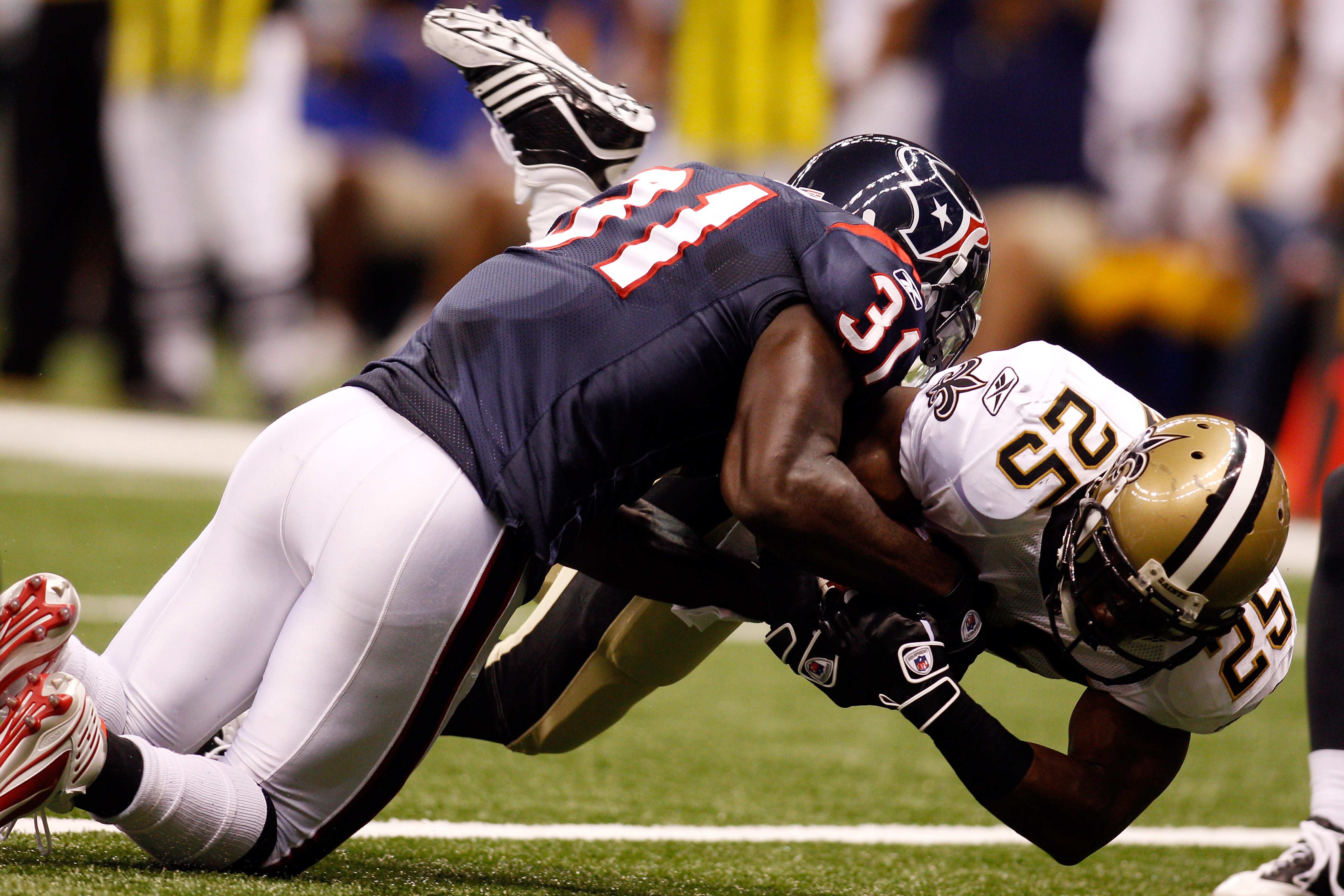 NEW ORLEANS - AUGUST 21:  Reggie Bush #25 of the New Orleans Saints is tackled as he scores a touchdown by Bernard Pollard #31 of the Houston Texans at the Louisiana Superdome on August 21, 2010 in New Orleans, Louisiana.  (Photo by Chris Graythen/Getty I