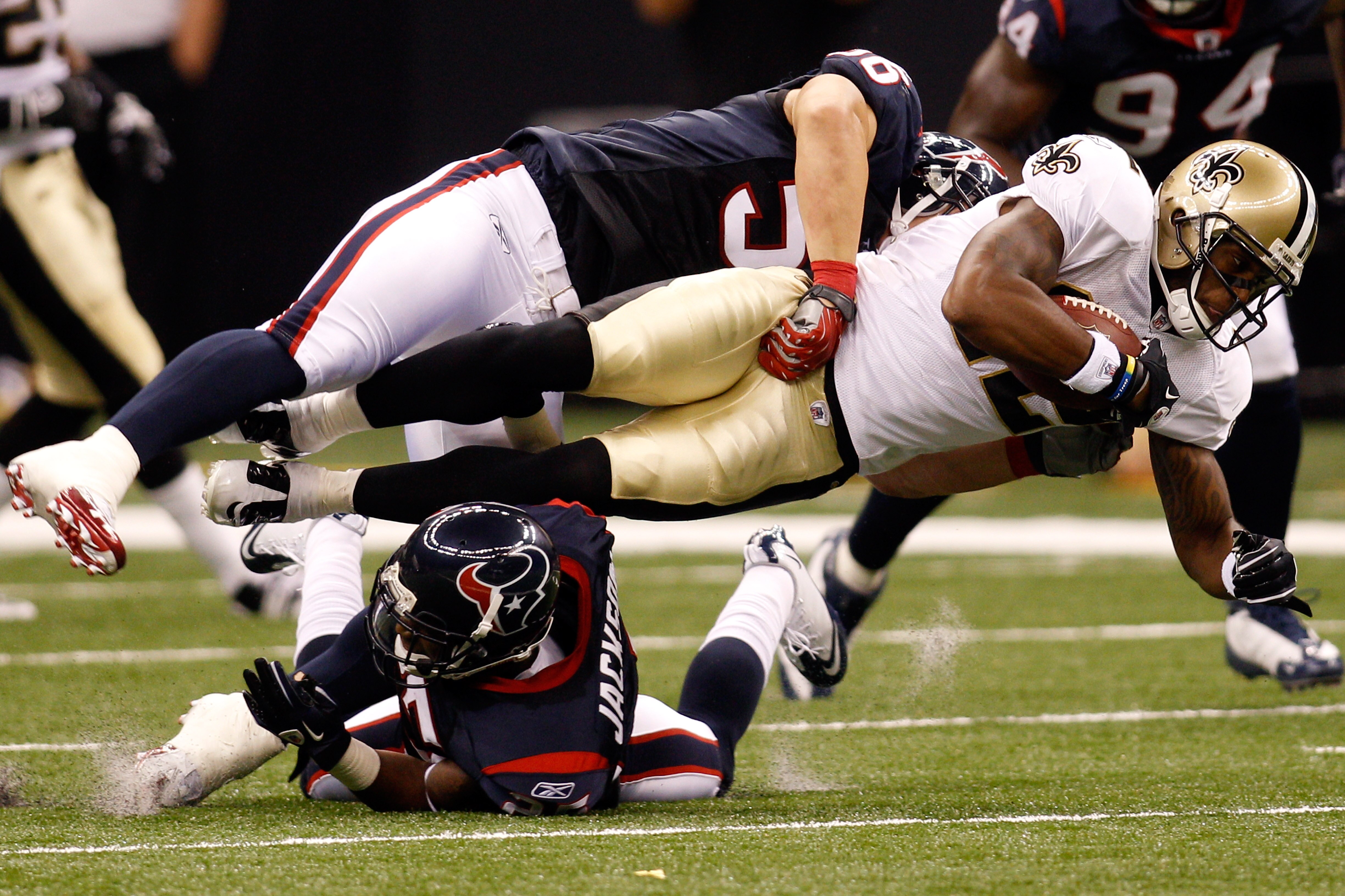 NEW ORLEANS - AUGUST 21:  Marques Colston #12 of the New Orleans Saints is tackled by Brian Cushing #56 and Kareem Jackson #25 of the Houston Texans at the Louisiana Superdome on August 21, 2010 in New Orleans, Louisiana.  (Photo by Chris Graythen/Getty I