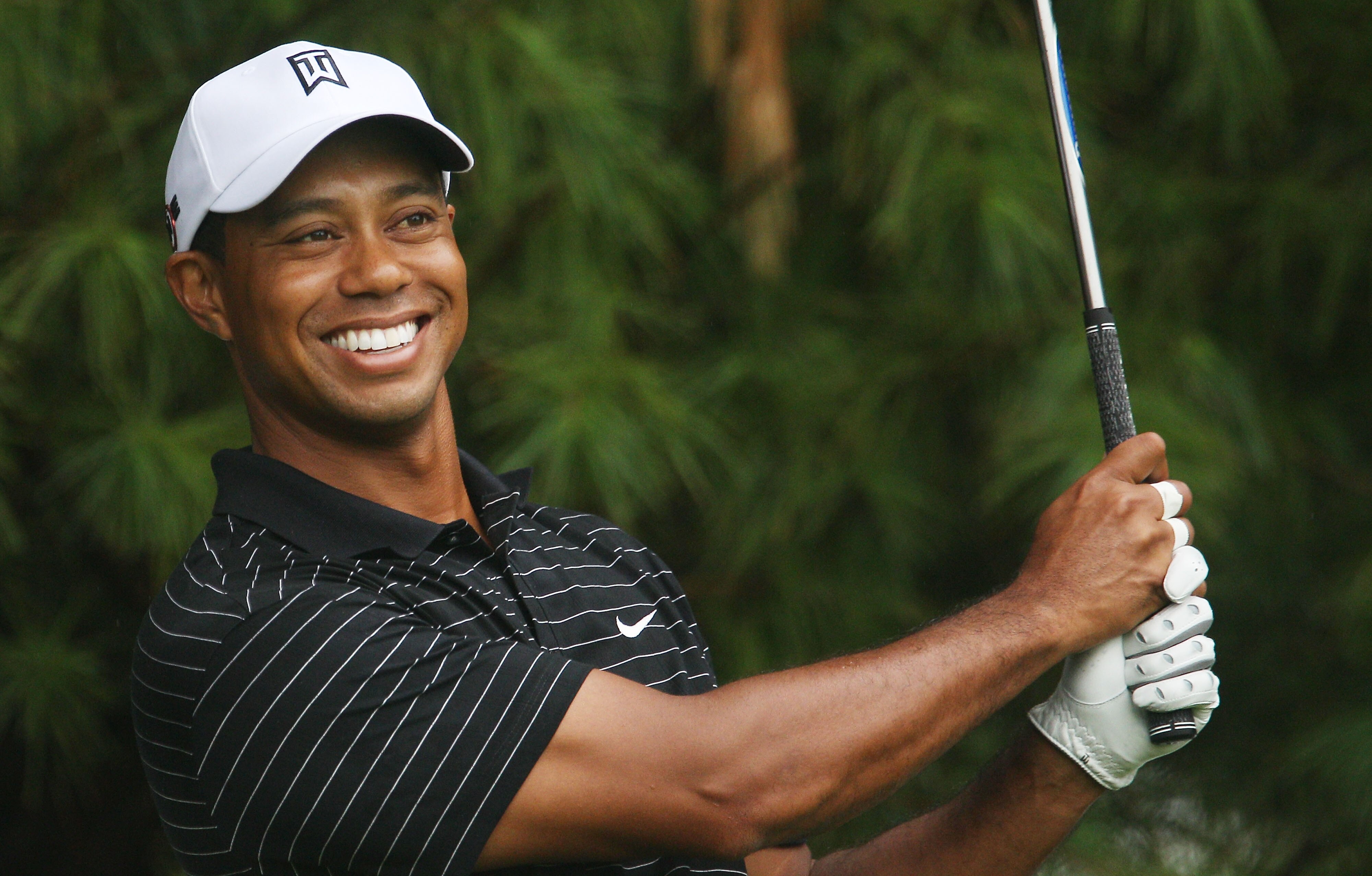 PARAMUS, NJ - AUGUST 25:  Tiger Woods smiles as he prepares to play a shot during the pro-am prior to the start of The Barclays at the Ridgewood Country Club on August 25, 2010 in Paramus, New Jersey.  (Photo by Scott Halleran/Getty Images)