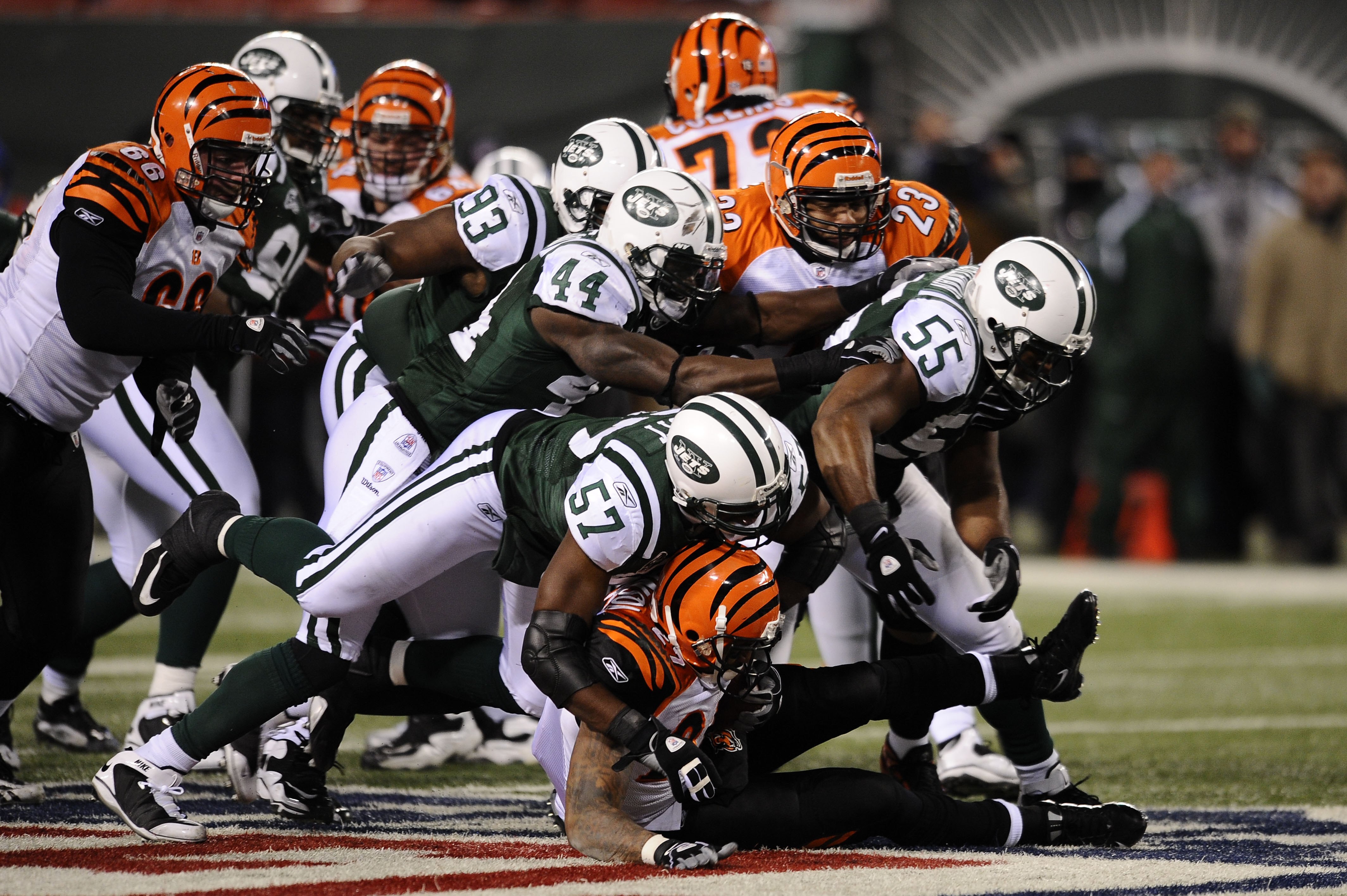 EAST RUTHERFORD, NJ - JANUARY 03:  Bart Scott #57 of the New York Jets takes down Larry Johnson #27 of the Cincinnati Bengals with the help of the defensive line during the second half of the game at Giants Stadium on January 3, 2010 in East Rutherford, N