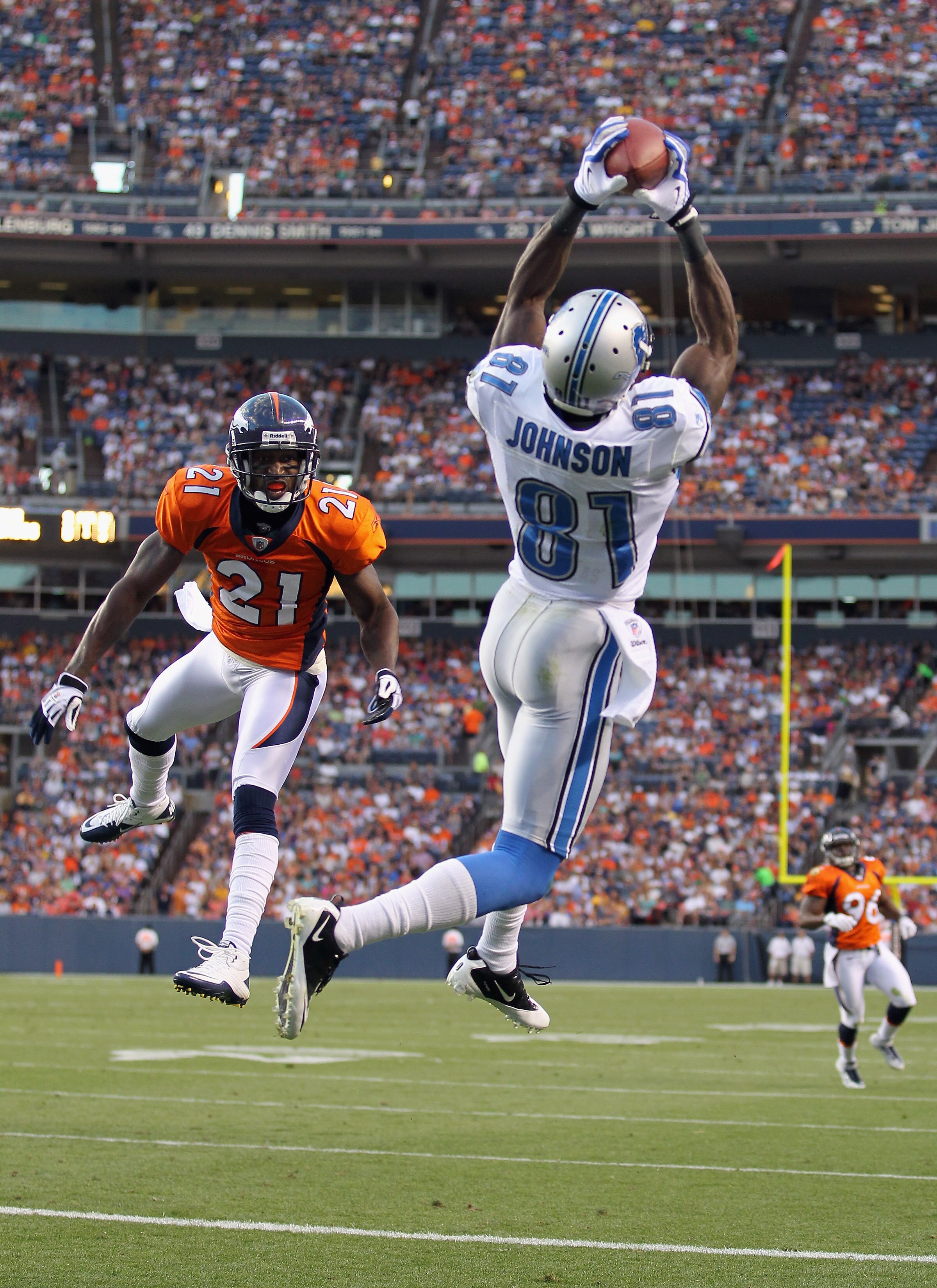 DENVER - AUGUST 21:  Calivin Johnson #81 of the Detroit Lions makes a 20 yard touchdown catch as Andre Goodman #21 of the Denver Broncos defends  during preseason NFL action at INVESCO Field at Mile High on August 21, 2010 in Denver, Colorado. The touchdo