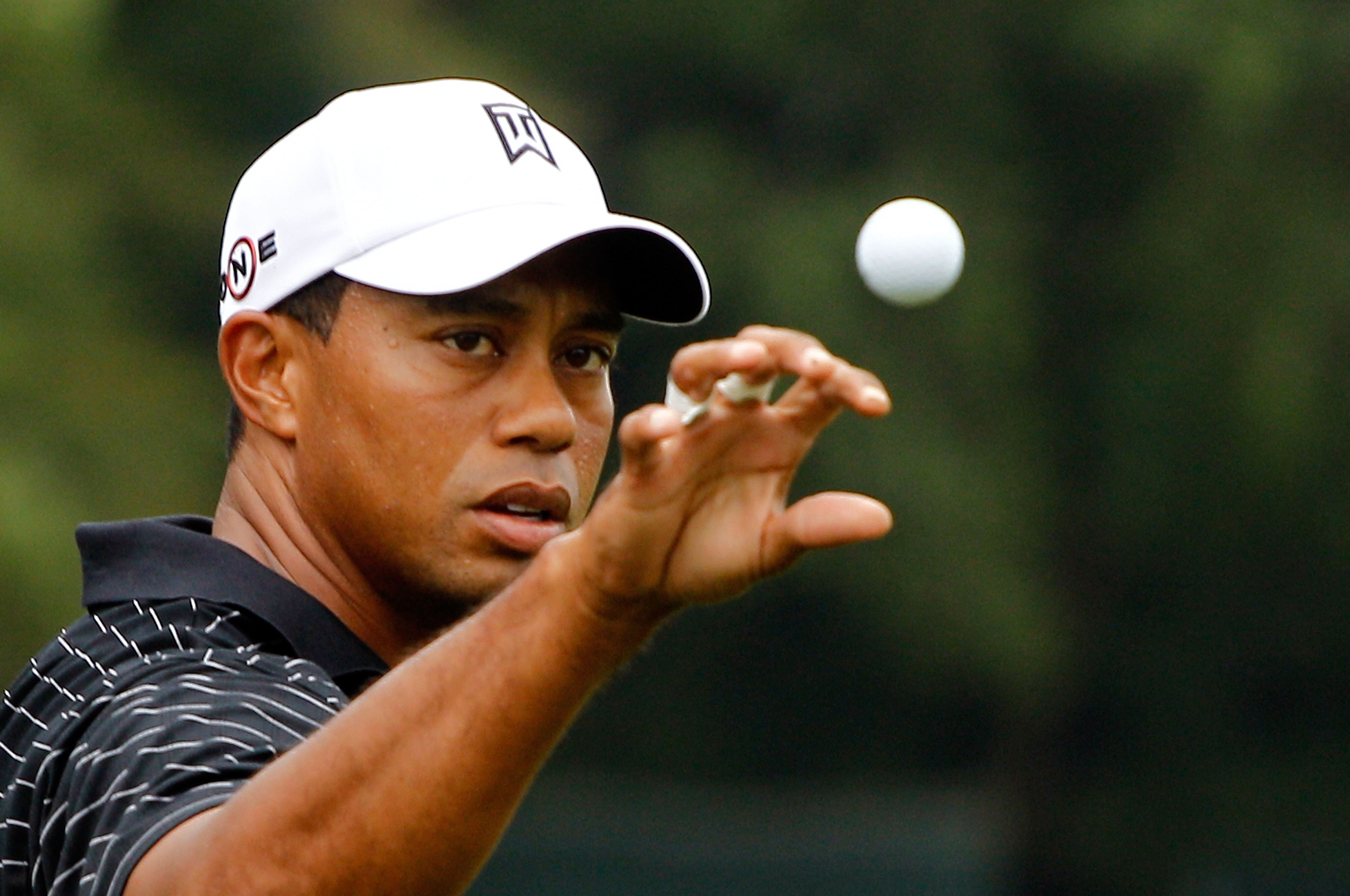 PARAMUS, NJ - AUGUST 25:  Tiger Woods reaches for a golf ball on the practice ground after the pro-am prior to the start of The Barclays at the Ridgewood Country Club on August 25, 2010 in Paramus, New Jersey.  (Photo by Scott Halleran/Getty Images)