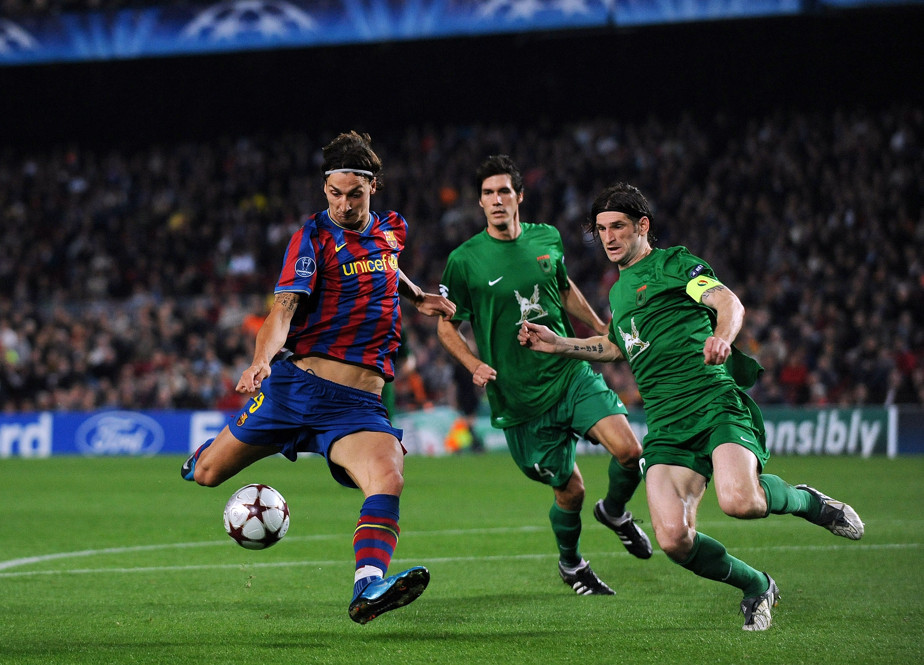 BARCELONA, SPAIN - OCTOBER 20:  Zlatan Ibrahimovic (L) of FC Barcelona scores his sides equalizing goal past Roman Sharonov of FC Rubin Kazan during the UEFA Champions League group F match between FC Barcelona and FC Rubin Kazan at the Camp Nou Stadium on