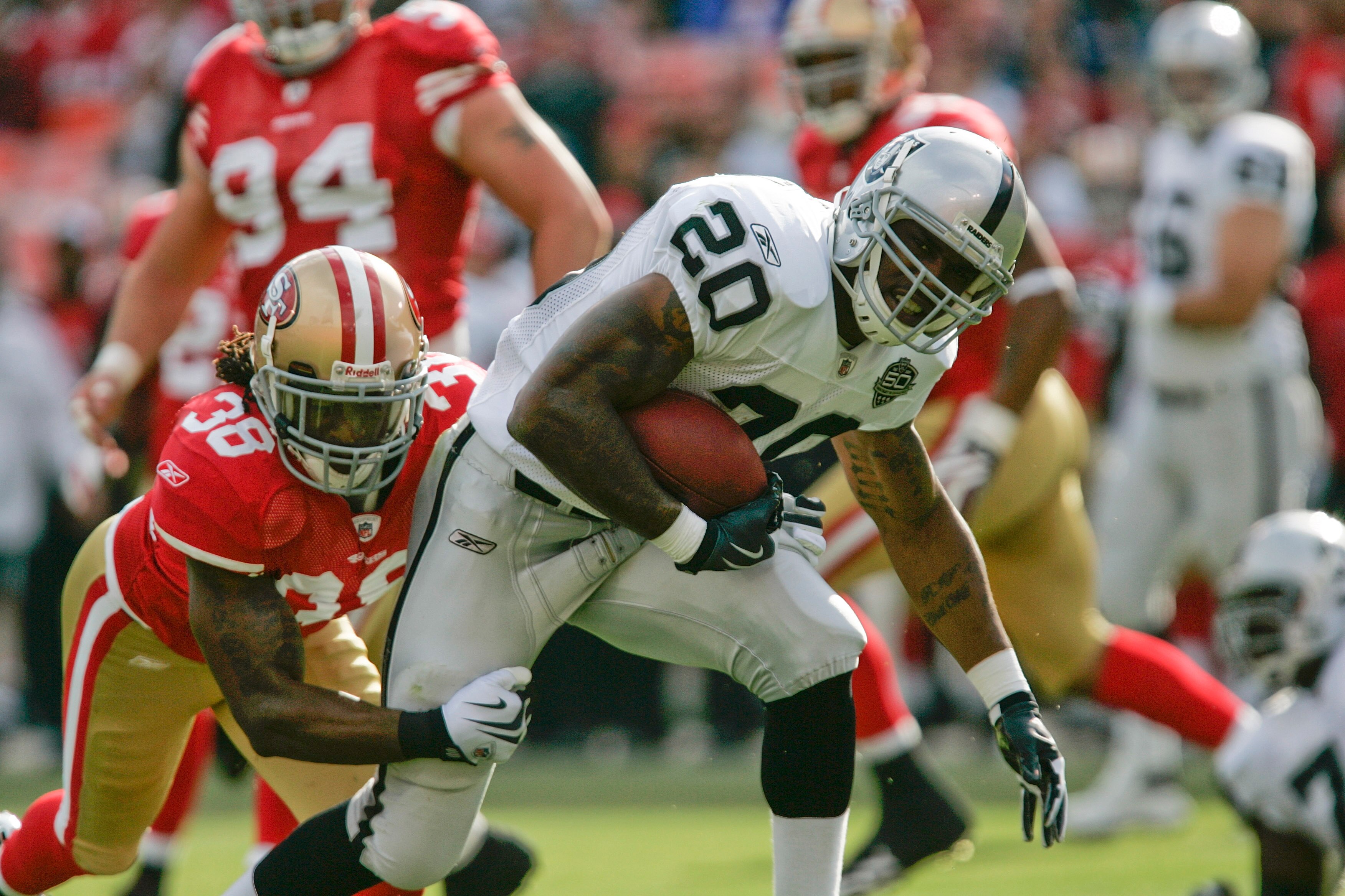 SAN FRANCISCO - AUGUST 22:  Oakland Raiders running back Darren McFadden #20 tries to break a tackle by San Francisco 49ers safety Dashon Goldson #38 during the 1st quarter as the San Francisco 49ers host the Oakland Raiders at Candlestick Park August 22,