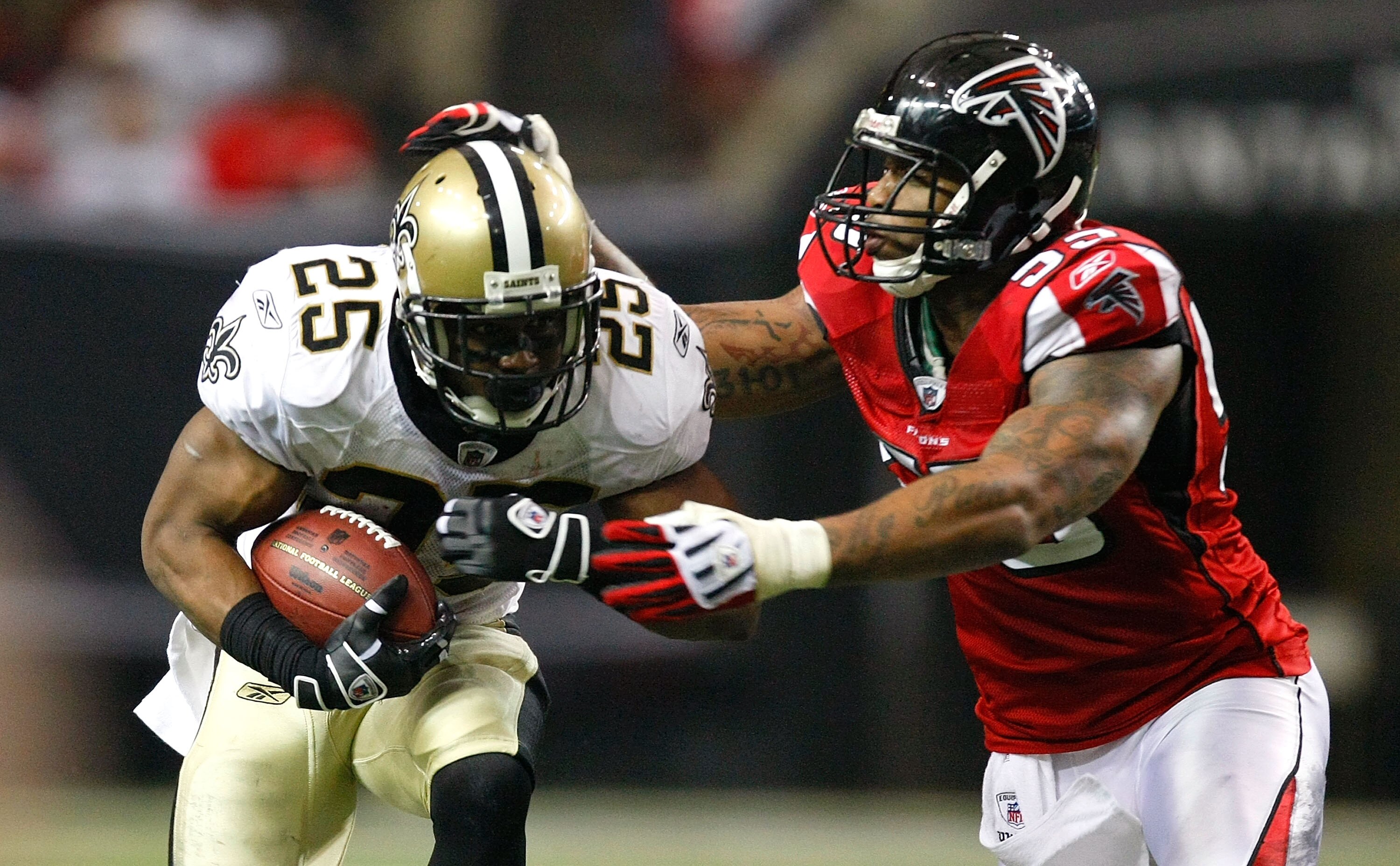 ATLANTA - DECEMBER 13:  Reggie Bush #25 of the New Orleans Saints runs the ball against John Abraham #55 of the Atlanta Falcons at Georgia Dome on December 13, 2009 in Atlanta, Georgia. The Saints won 26-23. (Photo by Kevin C. Cox/Getty Images)