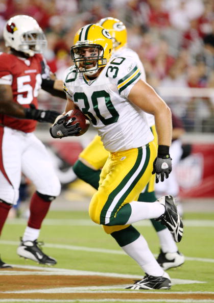 GLENDALE, AZ - AUGUST 28:  Fullback John Kuhn #30 of the Green Bay Packers rushes for a touchdown during the first quarter against the Arizona Cardinals at the University of Phoenix Stadium on August 28, 2009 in Glendale, Arizona.  (Photo by Christian Pet