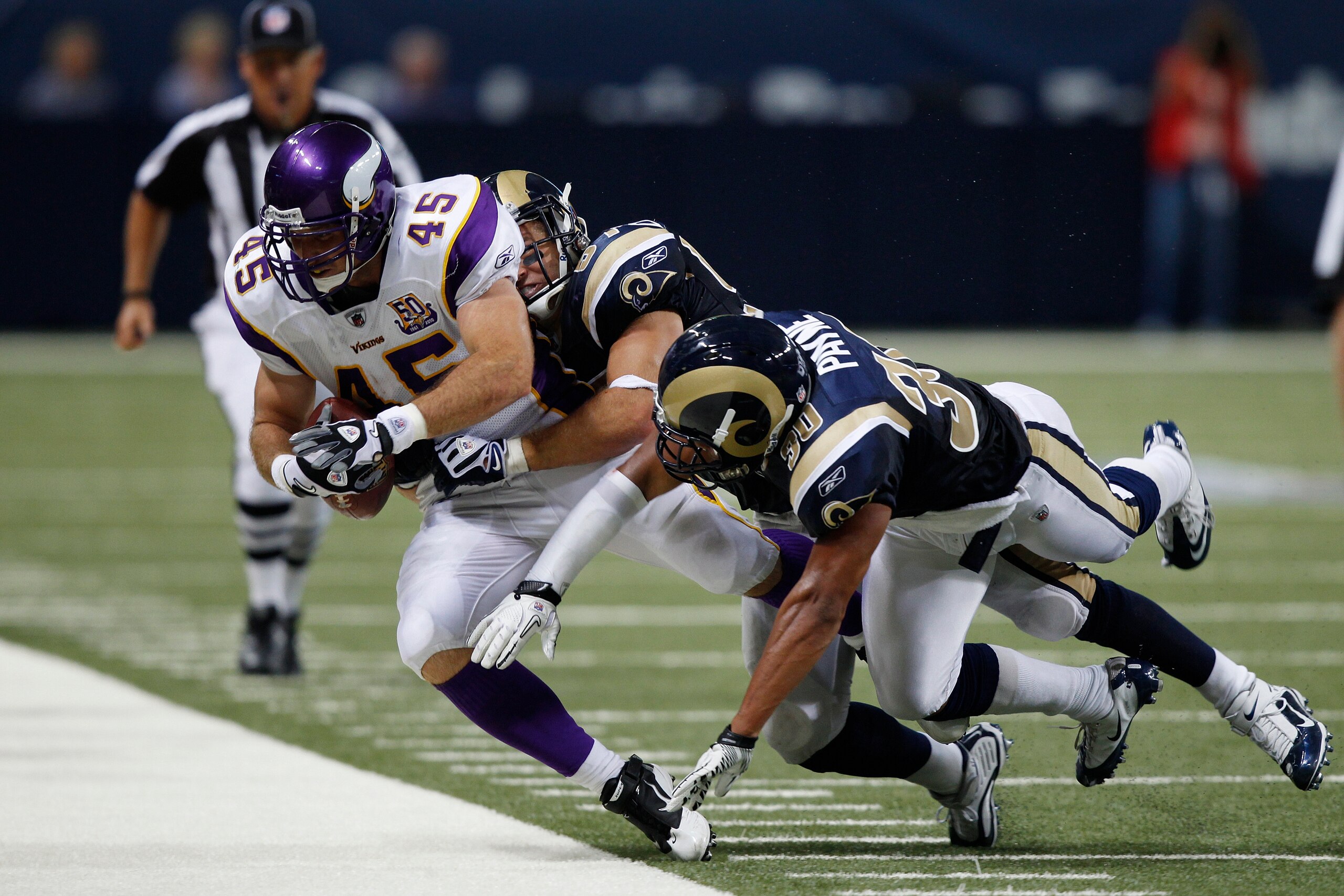 ST. LOUIS, MO - AUGUST 14: Kevin Payne #30 and Chris Chamberlain #57 of the St. Louis Rams tackle Garrett Mills #45 of the Minnesota Vikings during the preseason game at Edward Jones Dome on August 14, 2010 in St. Louis, Missouri. The Vikings defeated the ST. LOUIS, MO - AUGUST 14: Kevin Payne #30 and Chris Chamberlain #57 of the St. Louis Rams tackle Garrett Mills #45 of the Minnesota Vikings during the preseason game at Edward Jones Dome on August 14, 2010 in St. Louis, Missouri. The Vikings defeated the