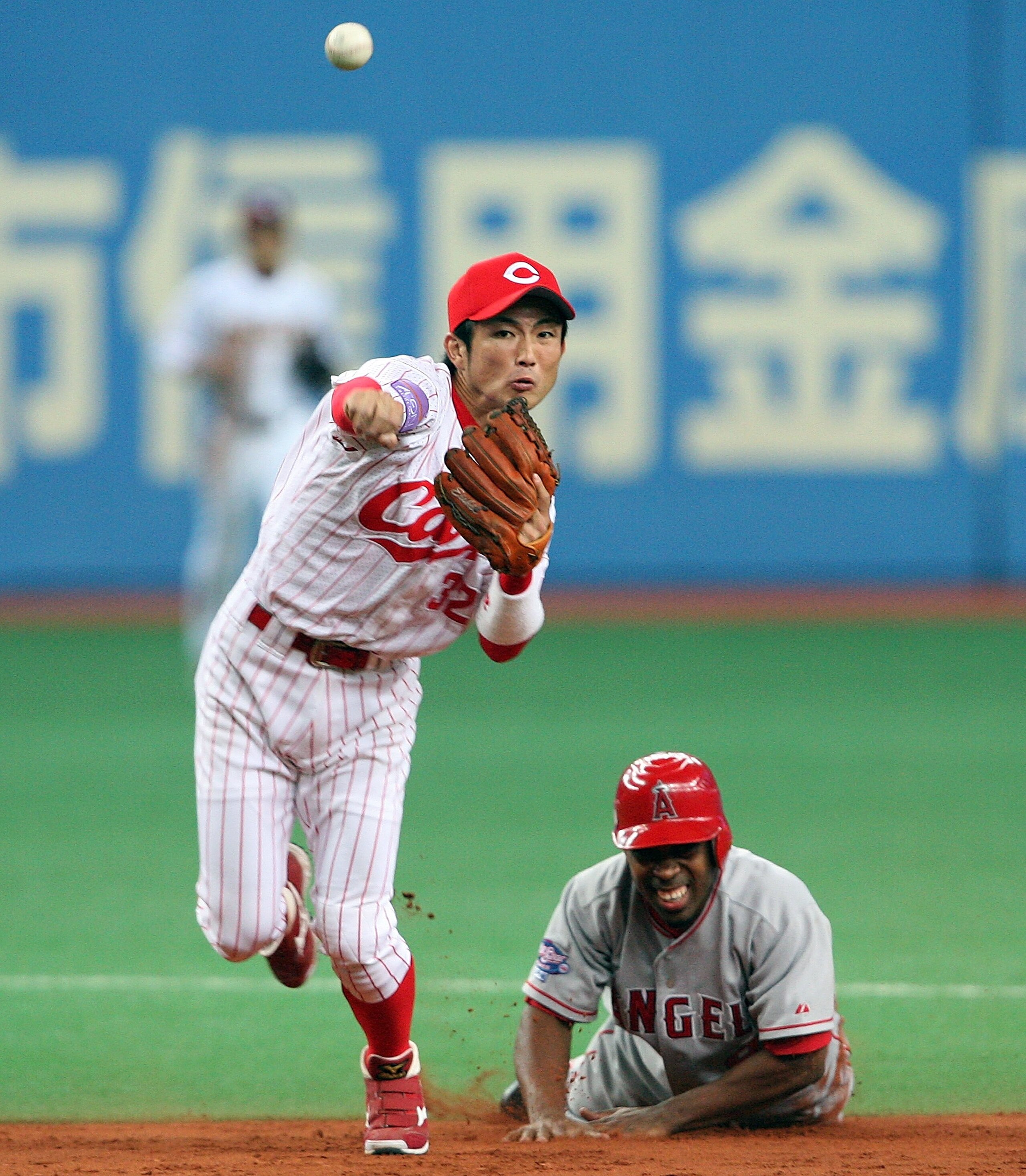 OSAKA, JAPAN - NOVEMBER 7: Eishin Soyogi #32 of Hiroshima Toyo Carp throws after forcing out Chone Figgins #9 of the Los Angeles Angels of Anaheim during the Aeon All Star Series Day 4 - MLB v Japan All-Stars at the Kyocera Dome on November 7, 2006 in Osa OSAKA, JAPAN - NOVEMBER 7: Eishin Soyogi #32 of Hiroshima Toyo Carp throws after forcing out Chone Figgins #9 of the Los Angeles Angels of Anaheim during the Aeon All Star Series Day 4 - MLB v Japan All-Stars at the Kyocera Dome on November 7, 2006 in Osa