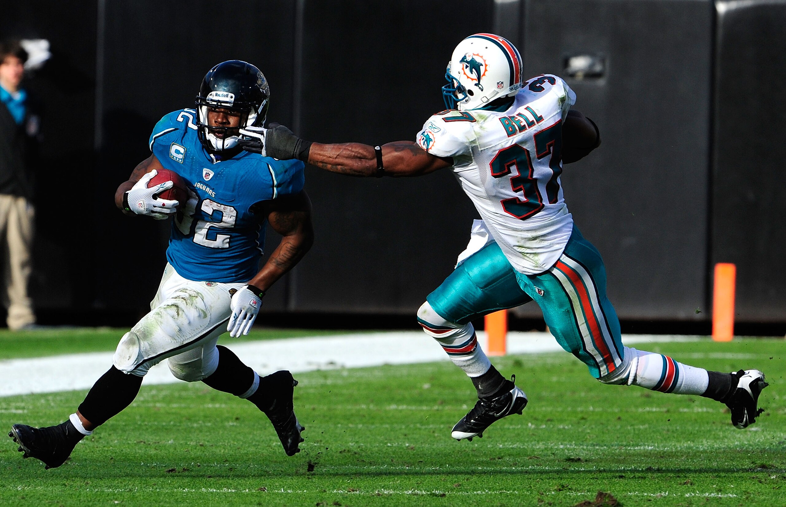 JACKSONVILLE, FL - DECEMBER 13:  Maurice Jones-Drew #32 of the Jacksonville Jaguars runs the ball against Yeremiah Bell #37 of the Miami Dolphins during the game at Jacksonville Municipal Stadium on December 13, 2009 in Jacksonville, Florida. The Dolphins