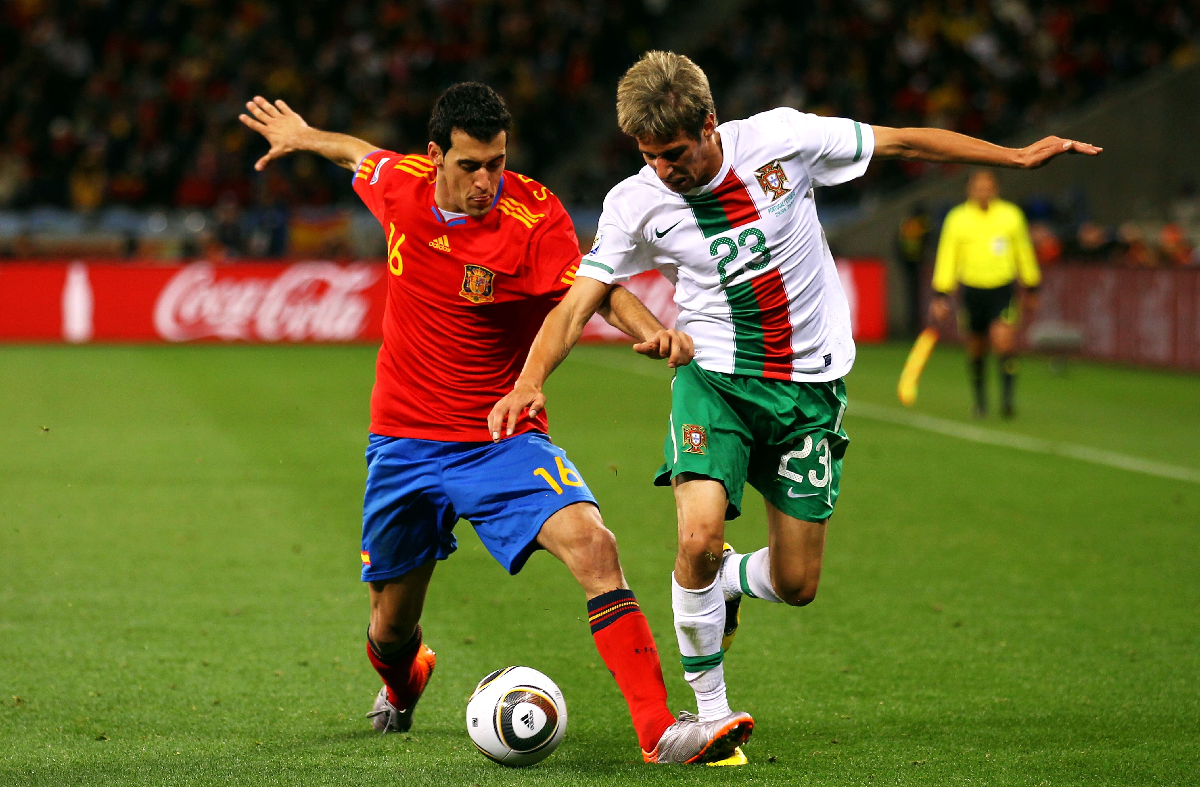 CAPE TOWN, SOUTH AFRICA - JUNE 29:  Sergio Busquets of Spain challenges Fabio Coentrao of Portugal during the 2010 FIFA World Cup South Africa Round of Sixteen match between Spain and Portugal at Green Point Stadium on June 29, 2010 in Cape Town, South Af