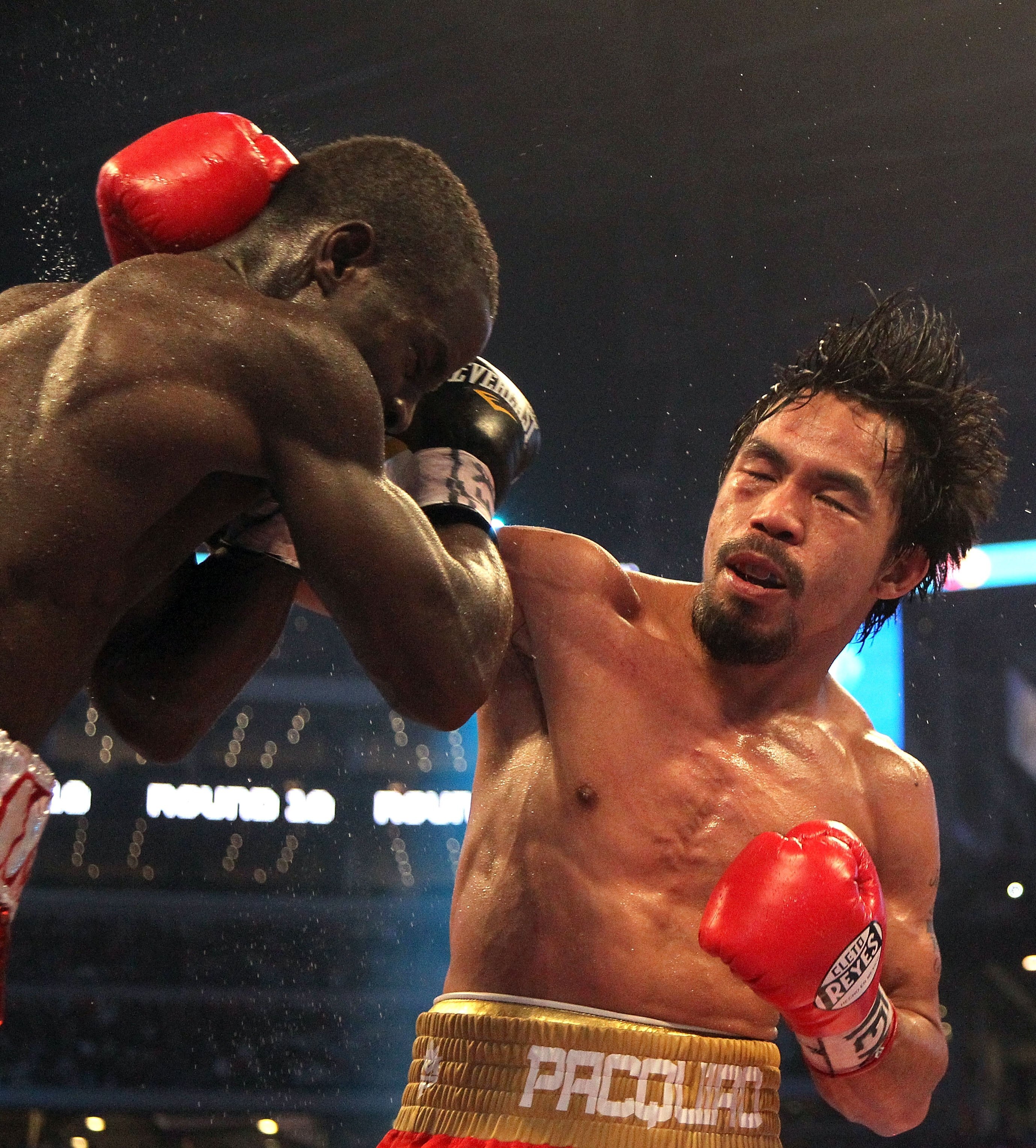 ARLINGTON, TX - MARCH 13:  (R-L) Manny Pacquiao of the Philippines throws a right to the head of Joshua Clottey of Ghana during the WBO welterweight title fight at Cowboys Stadium on March 13, 2010 in Arlington, Texas. Pacquiao defeated Clottey by unanimo