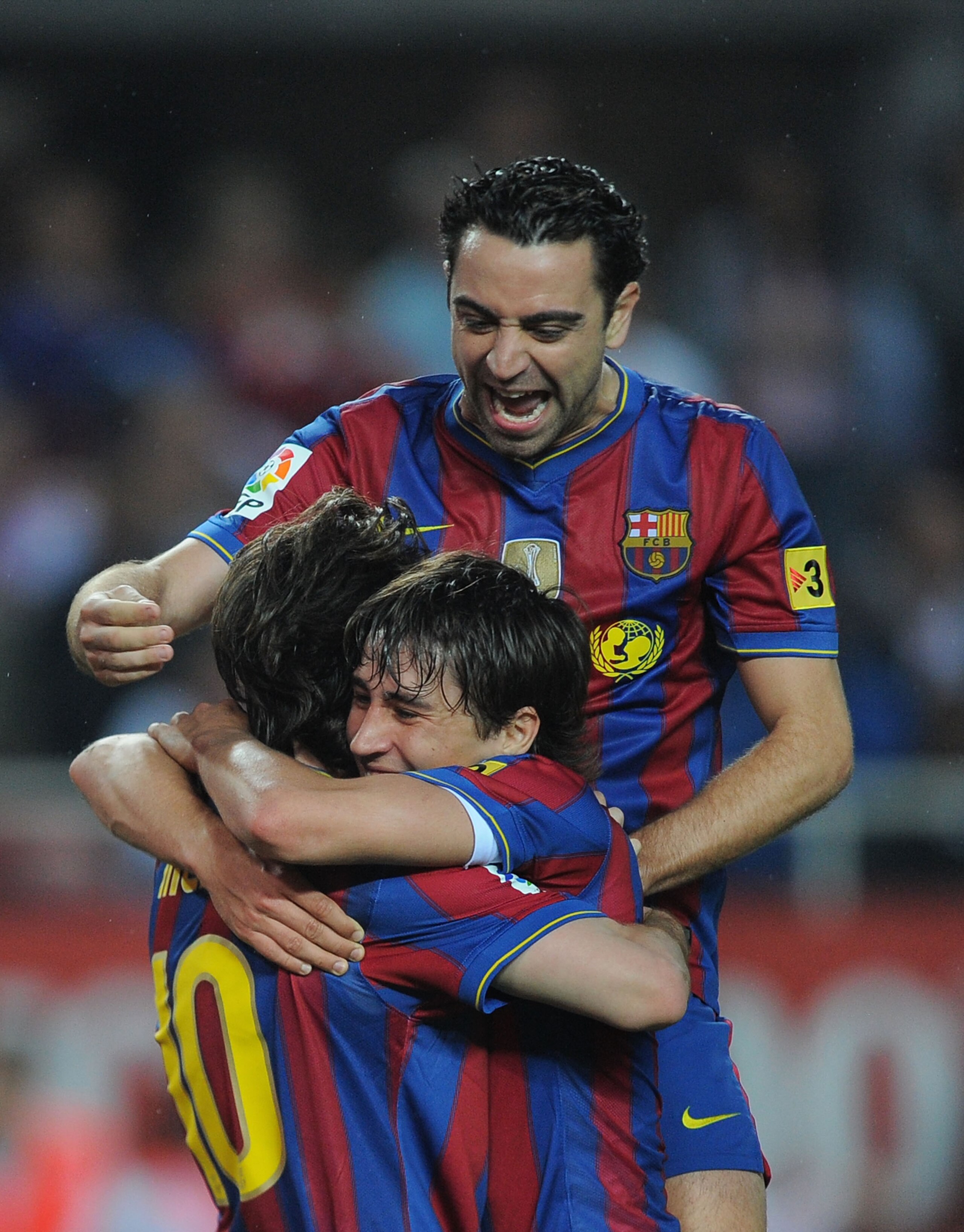 SEVILLE, SPAIN - MAY 08: Xavi Hernandez of Barcelona jumps on top of  Lionel Messi (L) and Bojan Krkic after Messi scored his team's first goal during the La Liga match between Sevilla and Barcelona at Estadio Ramon Sanchez Pizjuan on May 8, 2010 in Sevil