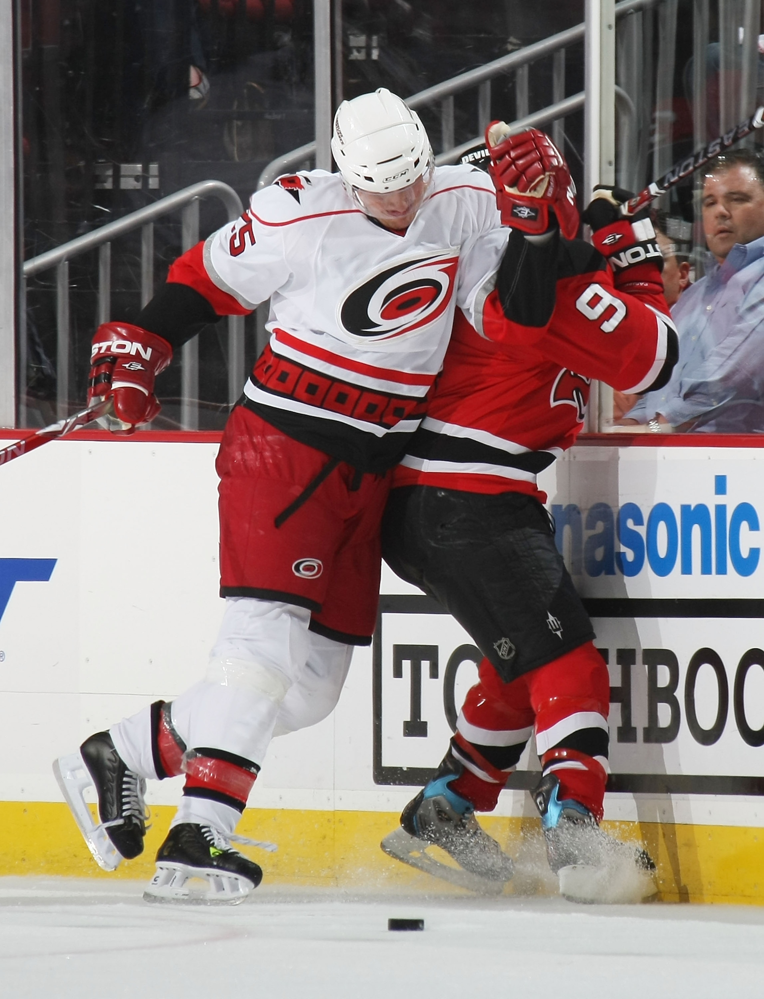 NEWARK, NJ - APRIL 17: Zach Parise #9 of the New Jersey Devils is hit into the boards by Joni Pitkanen #25 of the Carolina Hurricanes during Game Two of the Eastern Conference Quarterfinal Round of the 2009 NHL Stanley Cup Playoffs at the Prudential Cente