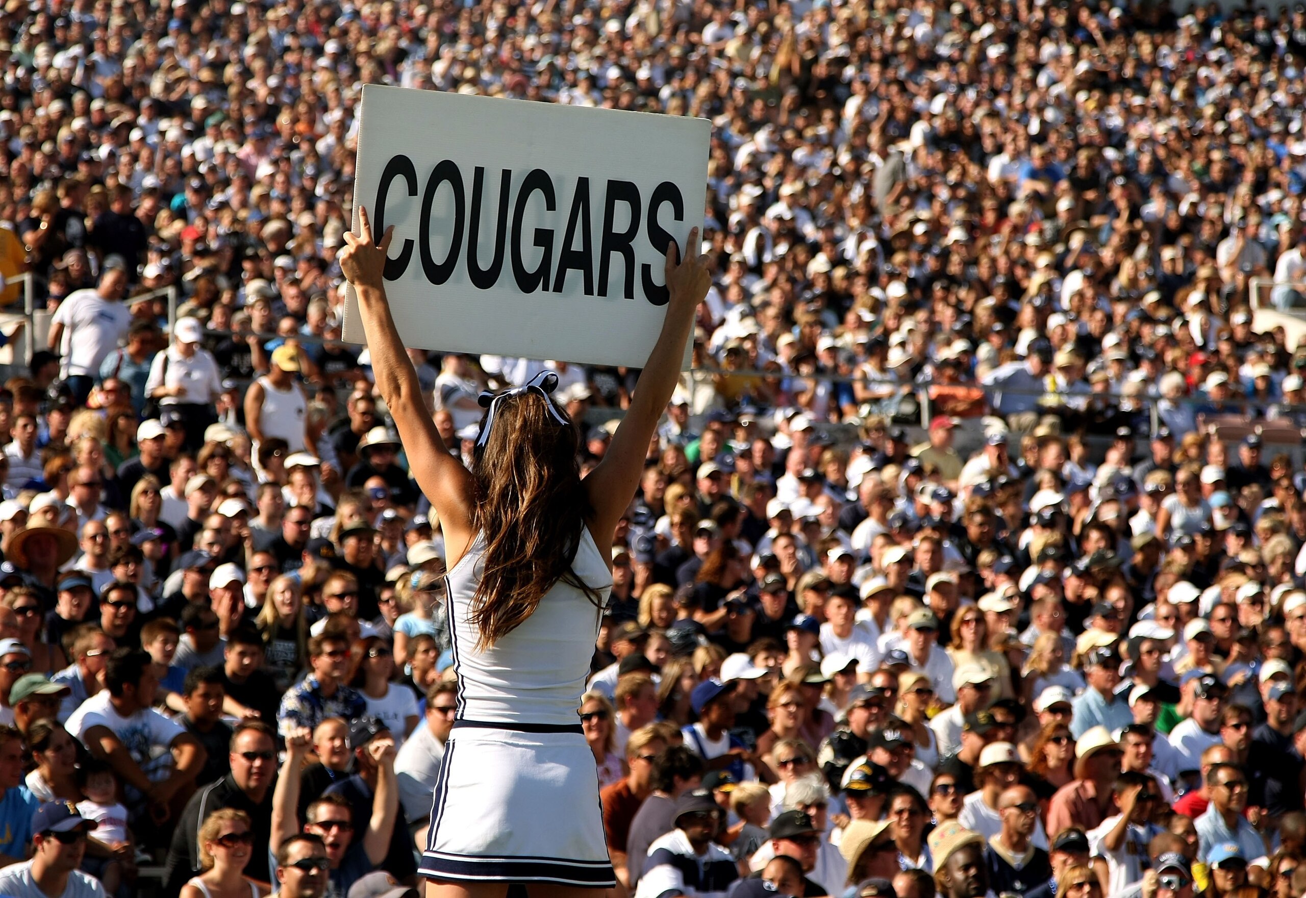 PASADENA, CA - SEPTEMBER 8:  A BYU Cougars cheerleader holds up a sign in front of the BYU section during the game with the UCLA Bruins on September 8, 2007 at the Rose Bowl in Pasadena, California. UCLA won 27-17. (Stephen Dunn/Getty Images)