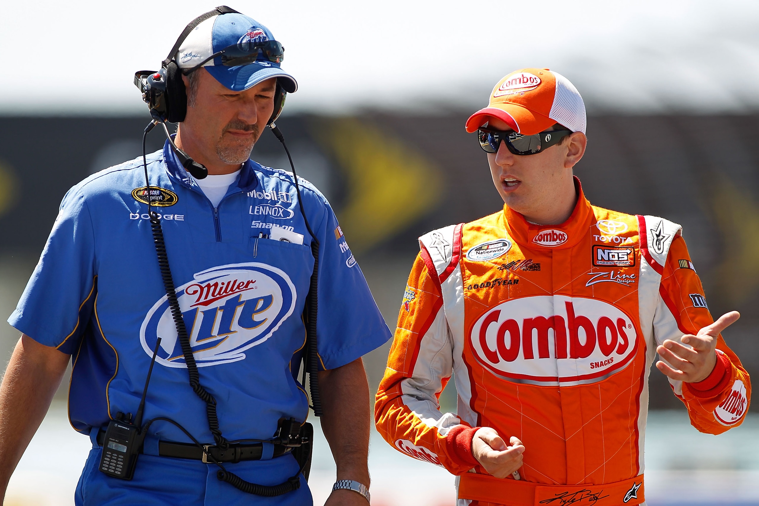 WATKINS GLEN, NY - AUGUST 07:  Kyle Busch (R), driver of the #18 M&M's Toyota, talks with Steve Addington (L), crew chief of the #2 Miller Lite Dodge, during qualifying for the NASCAR Sprint Cup Series Heluva Good! Sour Cream Dips at Watkins Glen Internat