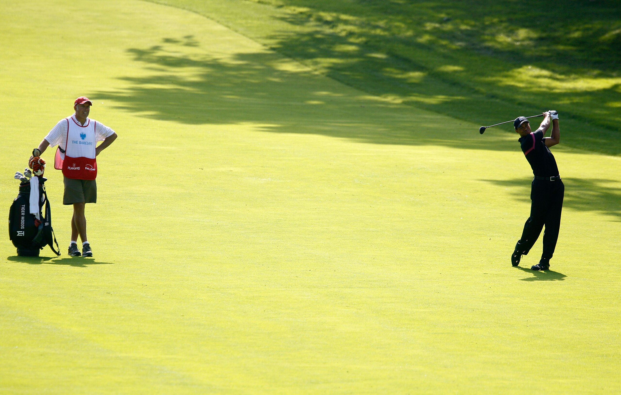 PARAMUS, NJ - AUGUST 26:  Tiger Woods watches his shot from the fairway on the 13th hole along with caddie Steve Williams during the first round of The Barclays at the Ridgewood Country Club on August 26, 2010 in Paramus, New Jersey.  (Photo by Scott Hall