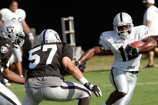 Jacoby Ford tries to get around Ricky Brown.