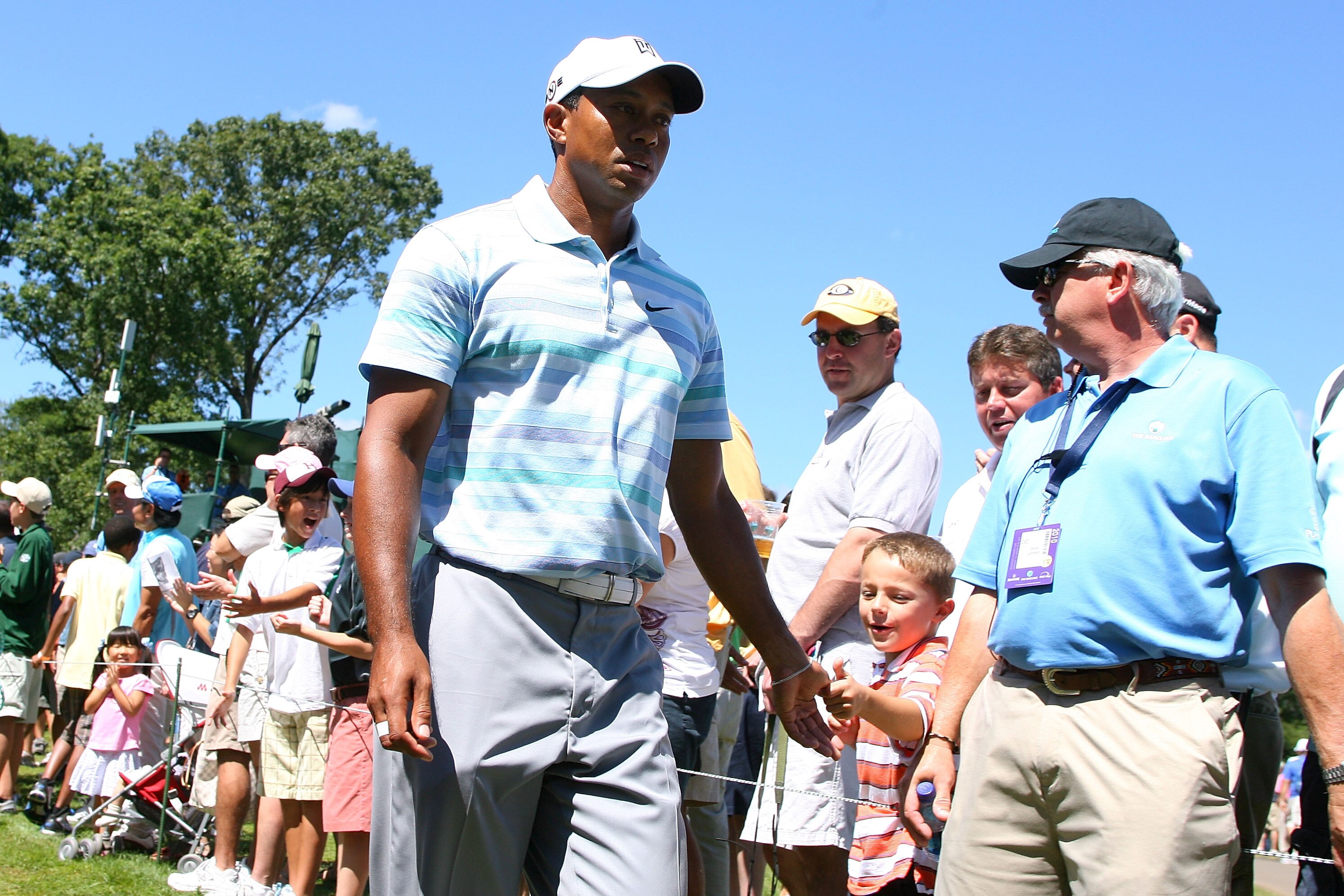 PARAMUS, NJ - AUGUST 27:  Tiger Woods greets a young fan as he walks towards the tee box on the 15th hole during the second round of The Barclays at the Ridgewood Country Club on August 27, 2010 in Paramus, New Jersey.  (Photo by Hunter Martin/Getty Image