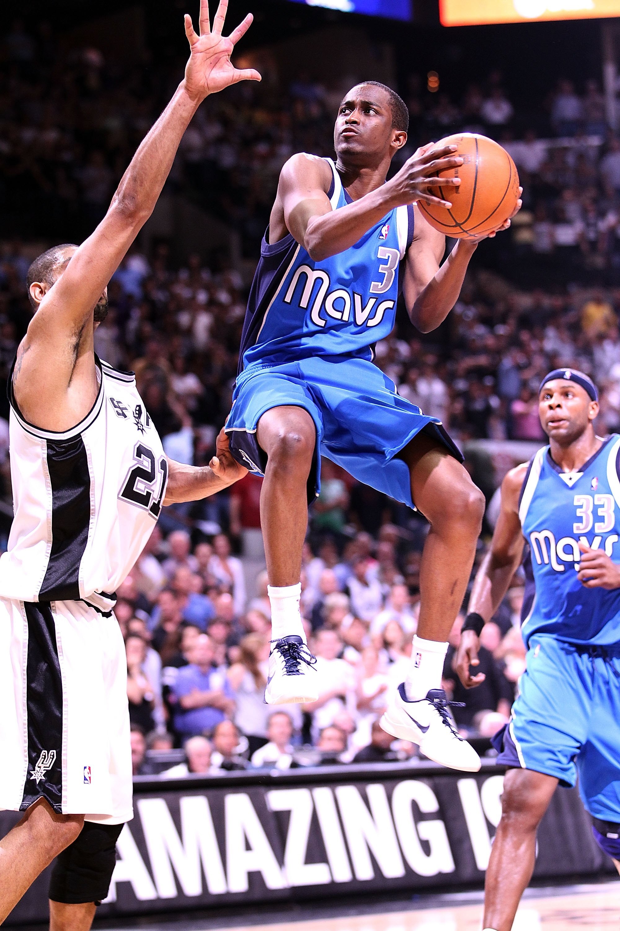 SAN ANTONIO - APRIL 23:  Guard Rodrigue Beaubois #3 of the Dallas Mavericks takes a shot against Tim Duncan #21 of the San Antonio Spurs in Game Three of the Western Conference Quarterfinals during the 2010 NBA Playoffs at AT&T Center on April 23, 2010 in