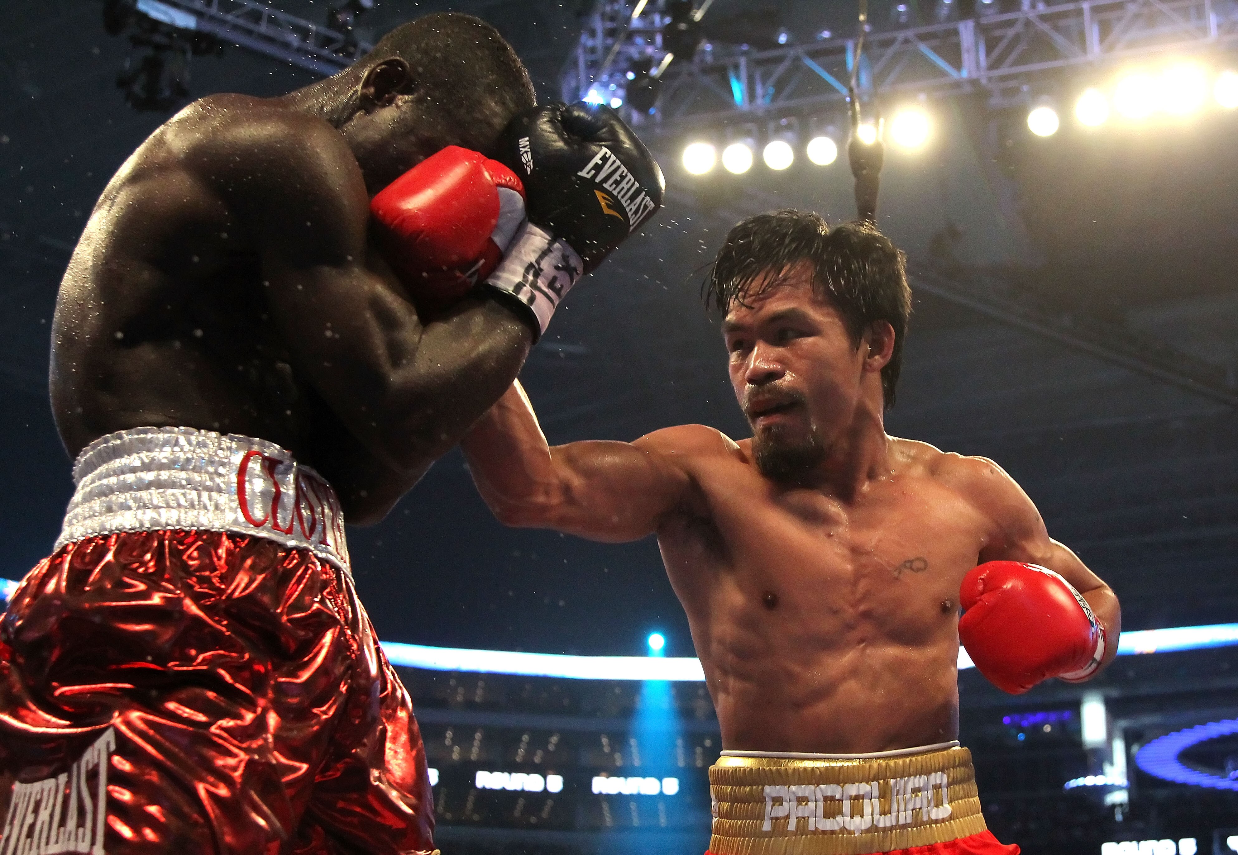 ARLINGTON, TX - MARCH 13:  (R-L) Manny Pacquiao of the Philippines throws a right to the head of Joshua Clottey of Ghana during the WBO welterweight title fight at Cowboys Stadium on March 13, 2010 in Arlington, Texas.  (Photo by Jed Jacobsohn/Getty Image