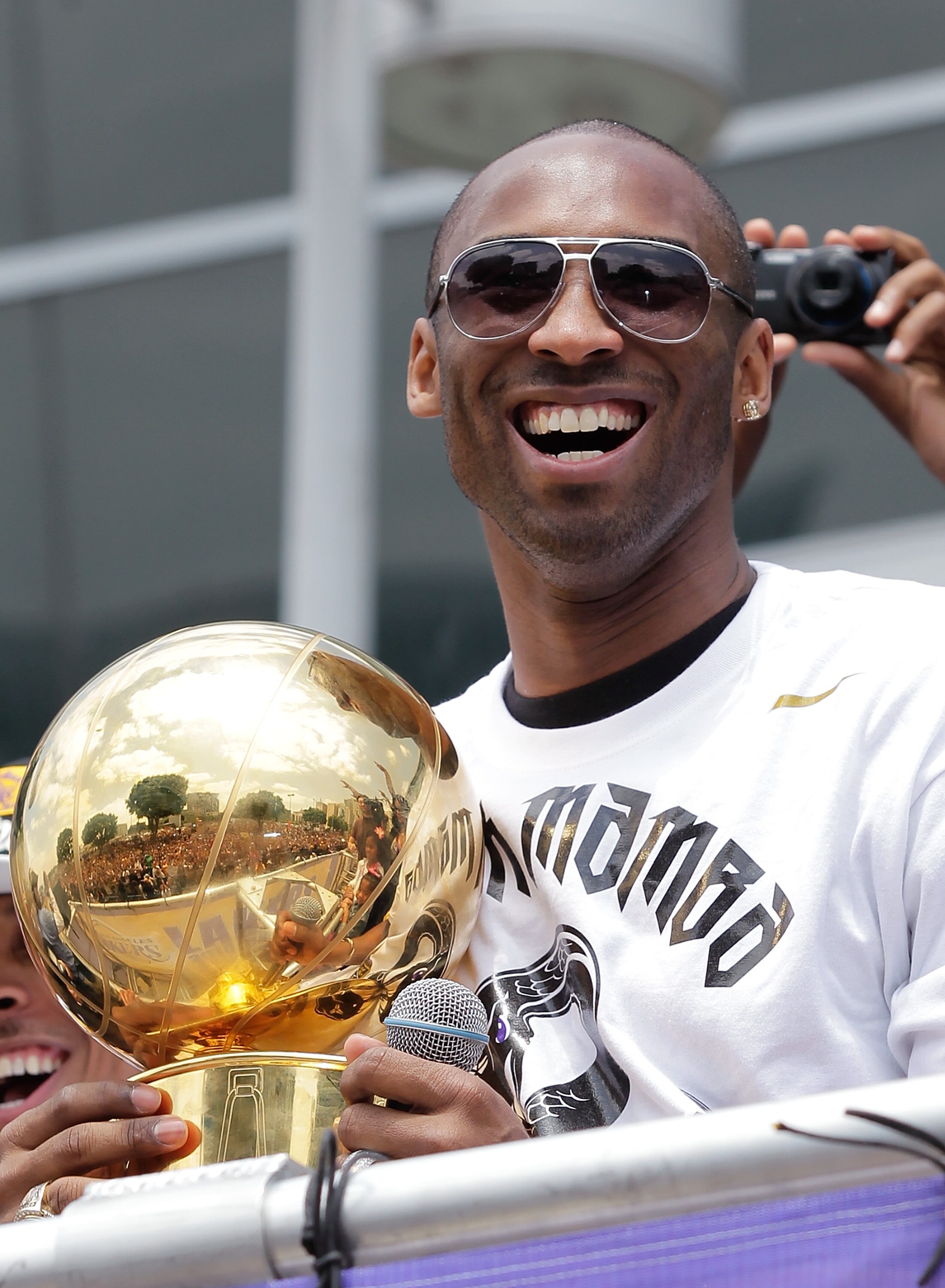 LOS ANGELES, CA - JUNE 21:  Los Angeles Lakers guard Kobe Bryant laughs with the championship trophy while riding in the victory parade for the the NBA basketball champion team on June 21, 2010 in Los Angeles, California. The Lakers beat the Boston Celtic