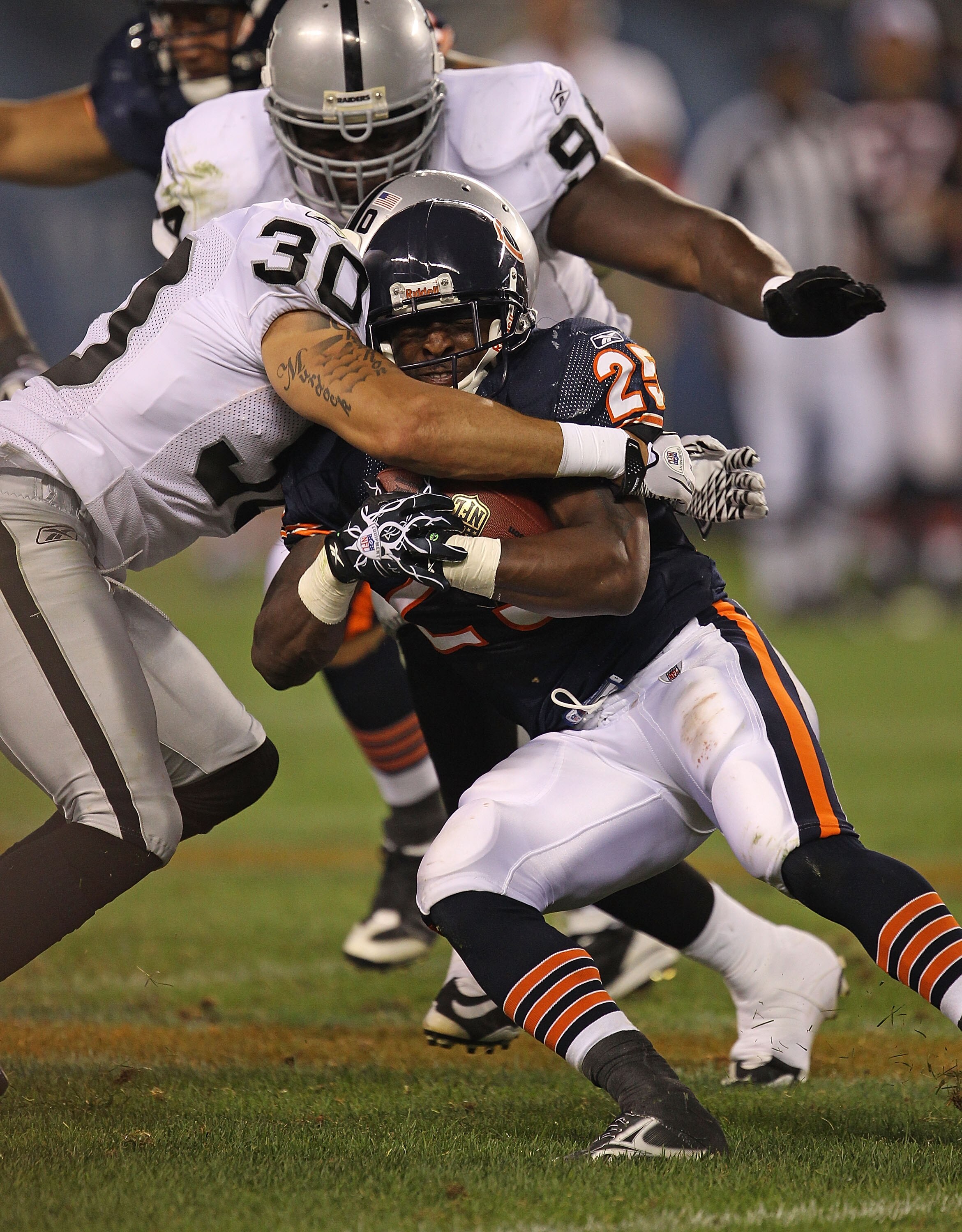CHICAGO - AUGUST 21: Garrett Wolfe #25 of the Chicago Bears is brought down by Jerome Boyd #30 of the Oakland Raiders during a preseason game at Soldier Field on August 21, 2010 in Chicago, Illinois. The Raiders defeated the Bears 32-17. (Photo by Jonatha