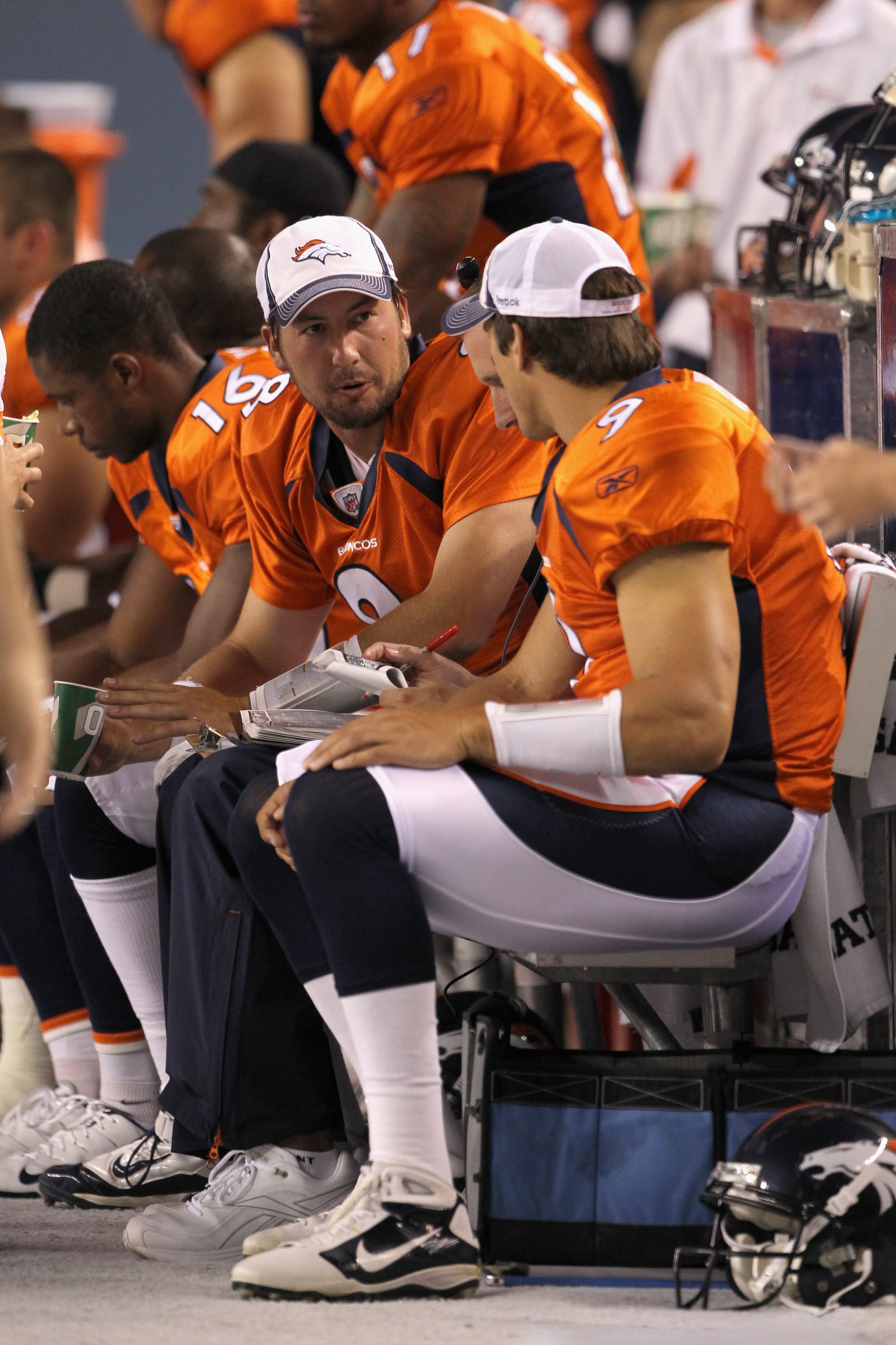 DENVER - AUGUST 21:  Quarterbacks Kyle Orton #8 and Brady Quinn #9 of the Denver Broncos talk on the bench as the defense takes the field against the Detroit Lions during preseason NFL action at INVESCO Field at Mile High on August 21, 2010 in Denver, Col