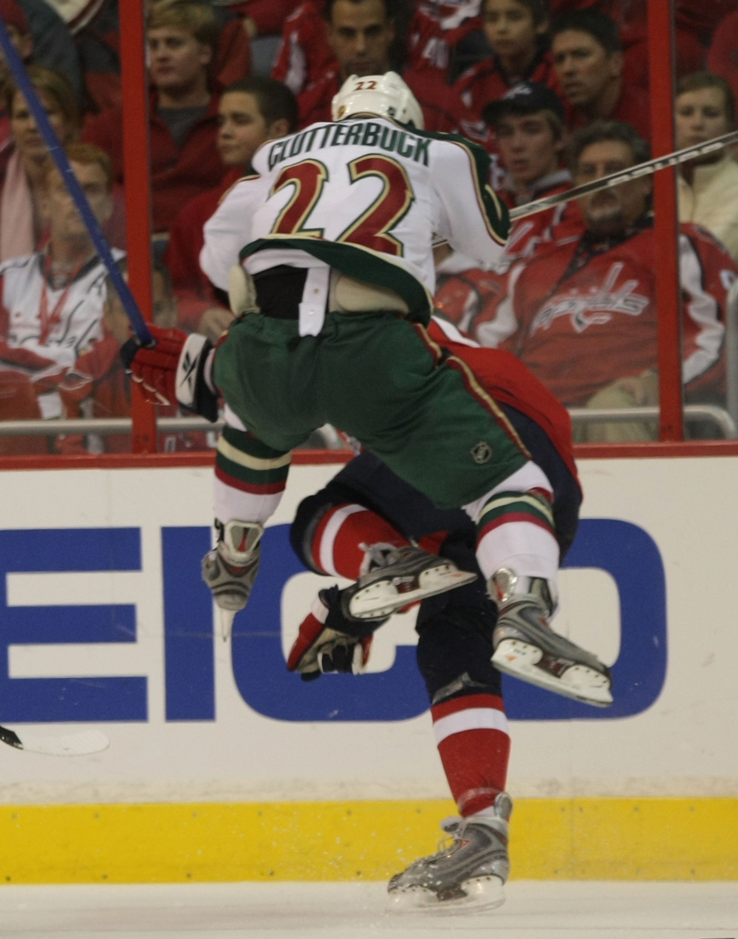 WASHINGTON - NOVEMBER 13: Mike Green #52 of the Washington Capitals is hit by Cal Clutterbuck #22 of the Minnesota Wild at the Verizon Center on November 13, 2009 in Washington, DC.  (Photo by Bruce Bennett/Getty Images)