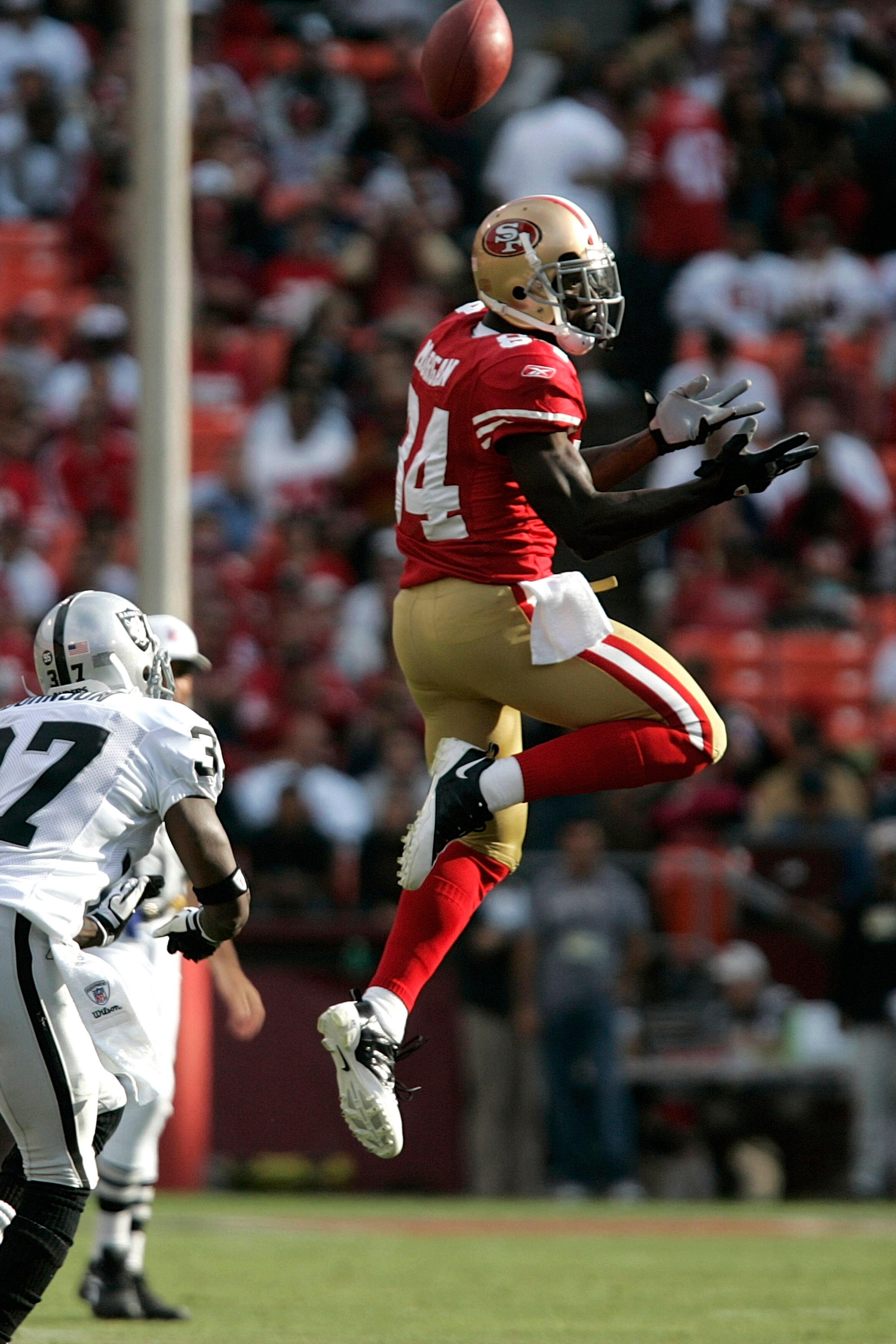 SAN FRANCISCO - AUGUST 22:   San Francisco 49ers wide receiver Josh Morgan #84 goes up for the ball as Oakland Raiders cornerback Chris Johnson #37 defends during the 1st quarter as the San Francisco 49ers host the Oakland Raiders at Candlestick Park Augu