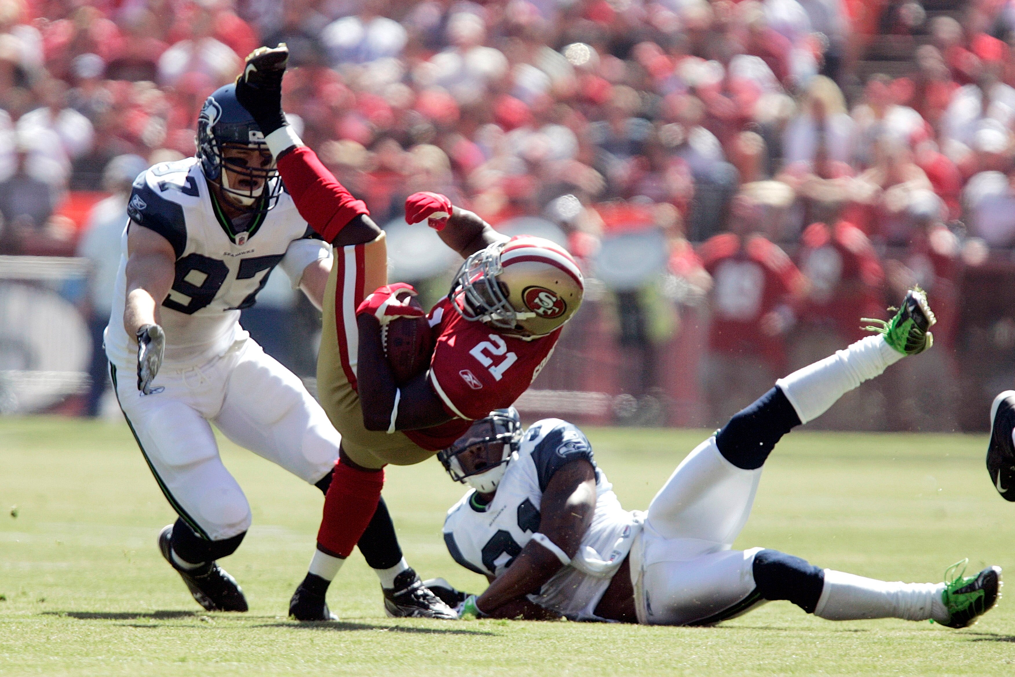 SAN FRANCISCO - SEPTEMBER 20:  Running back Frank Gore #21 of the San Francisco 49ers breaks a tackle by cornerback Ken Lucas #31 and defensive end Patrick Kerney of the Seattle Seahawks in the first quarter during the home opener at Candlestick Park on S