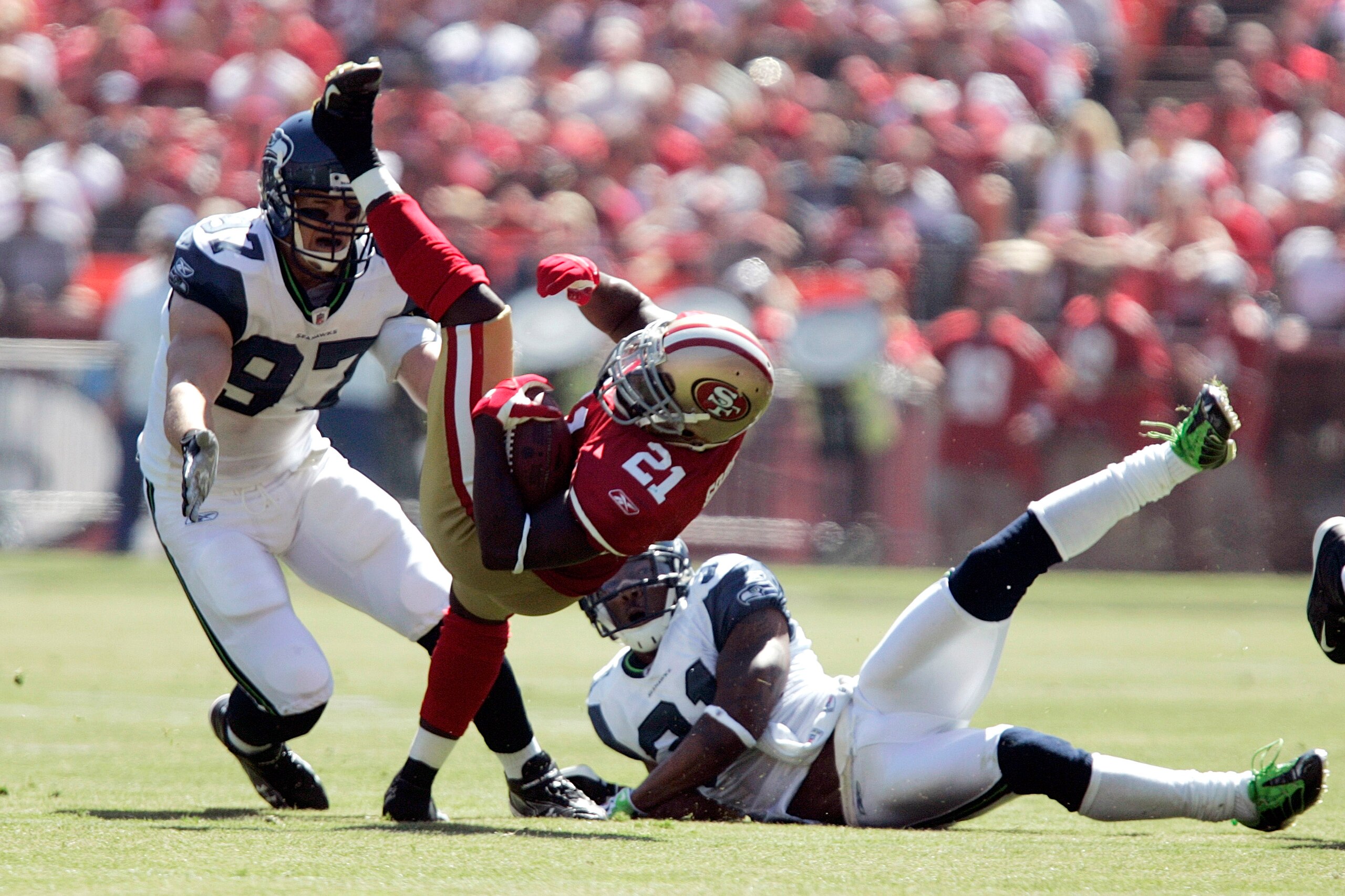 SAN FRANCISCO - SEPTEMBER 20:  Running back Frank Gore #21 of the San Francisco 49ers breaks a tackle by cornerback Ken Lucas #31 and defensive end Patrick Kerney of the Seattle Seahawks in the first quarter during the home opener at Candlestick Park on S