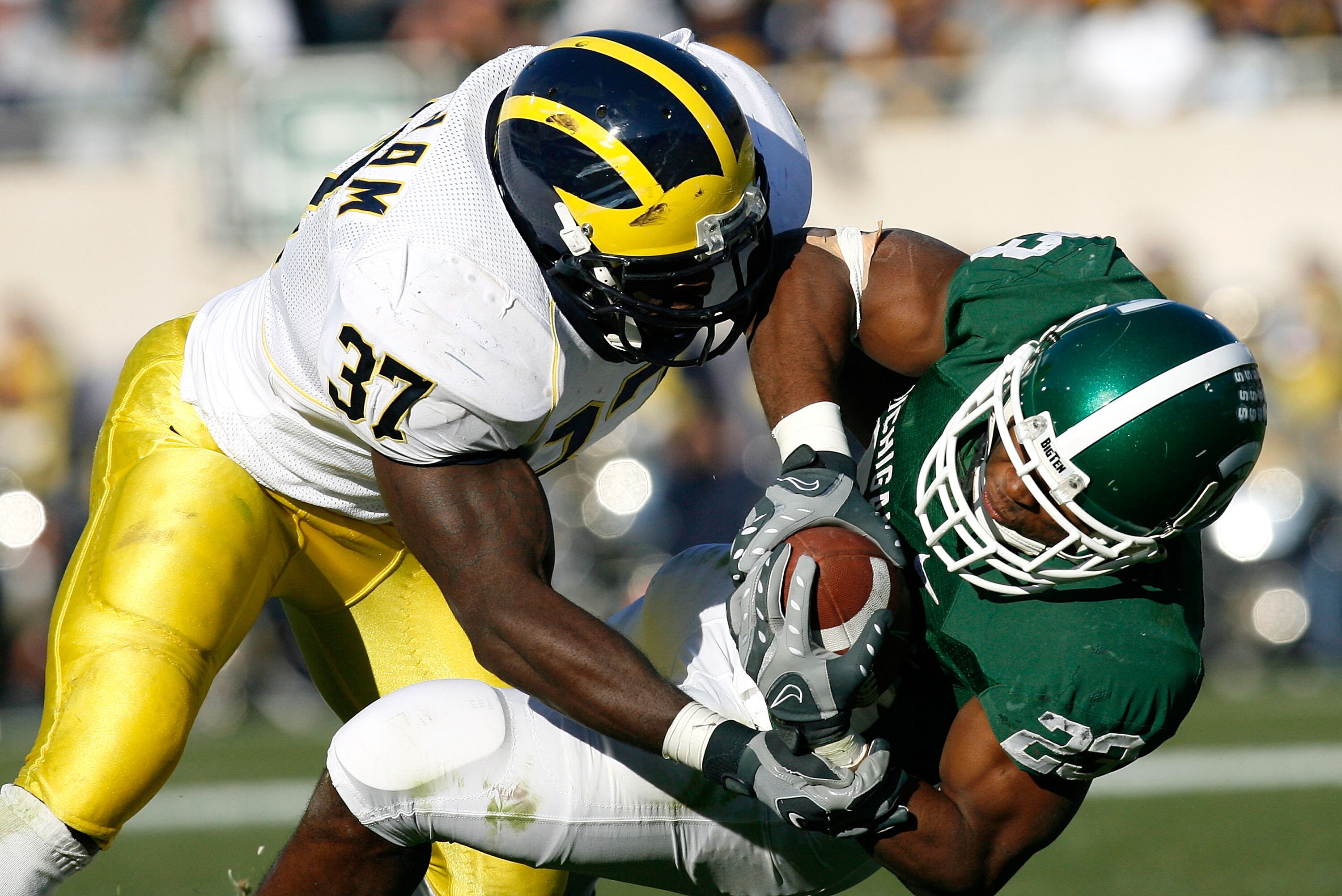 EAST LANSING, MI - NOVEMBER 03:  Linebacker Chris Graham #37 of the Michigan Wolverines lays a hard hit on running back Javon Ringer #23 of the Michigan State Spartans during the first half at Spartan Stadium November 3, 2007 in East Lansing, Michigan.  (