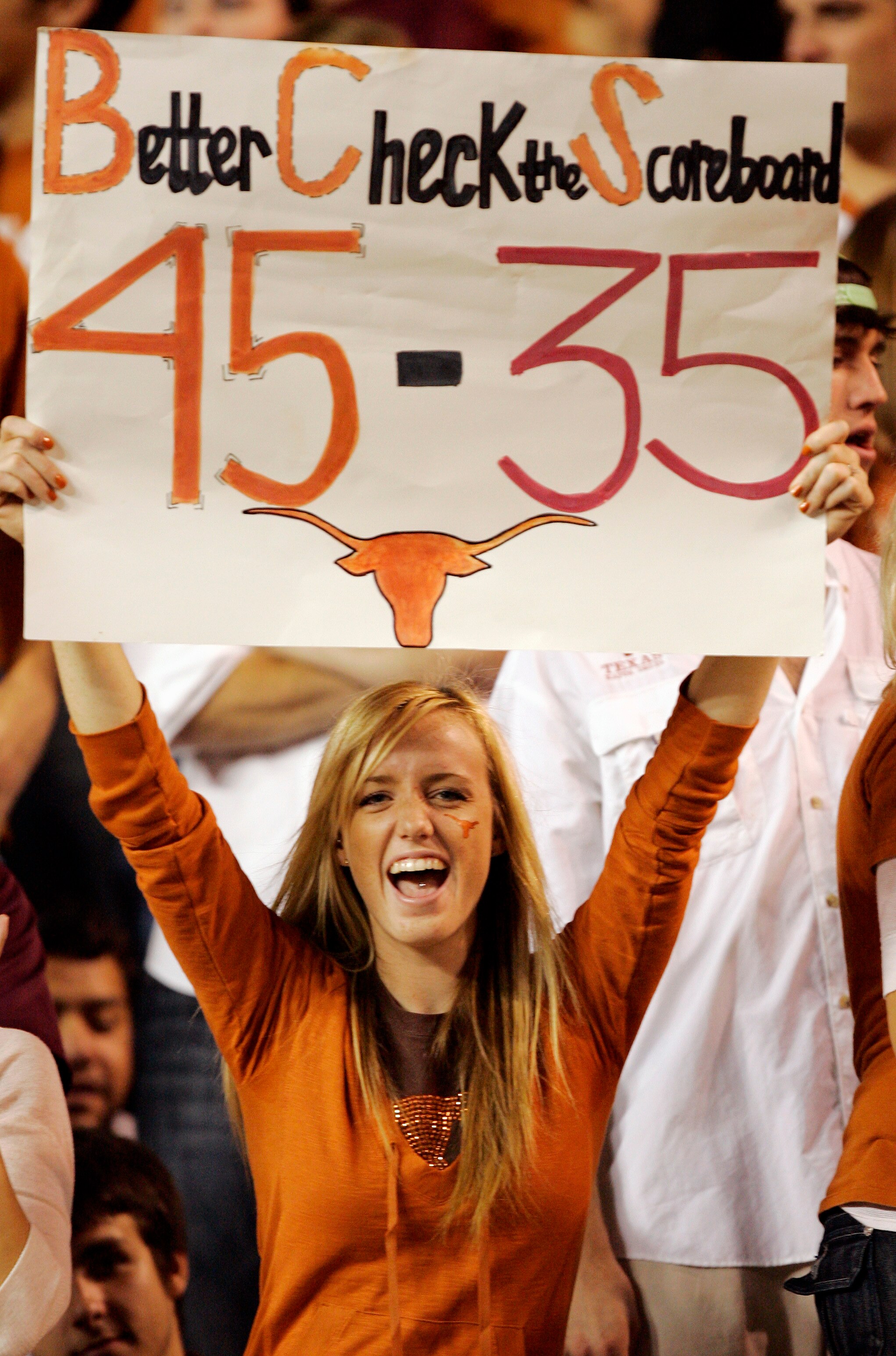 AUSTIN, TX - NOVEMBER 27:  A Texas Longhorn fan cheers on her team against the Texas A&M Aggies while holding a reminder of the Texas score against Oklahoma earlier in the season at Darrell K Royal-Texas Memorial Stadium November 27, 2008 in Austin, Texas