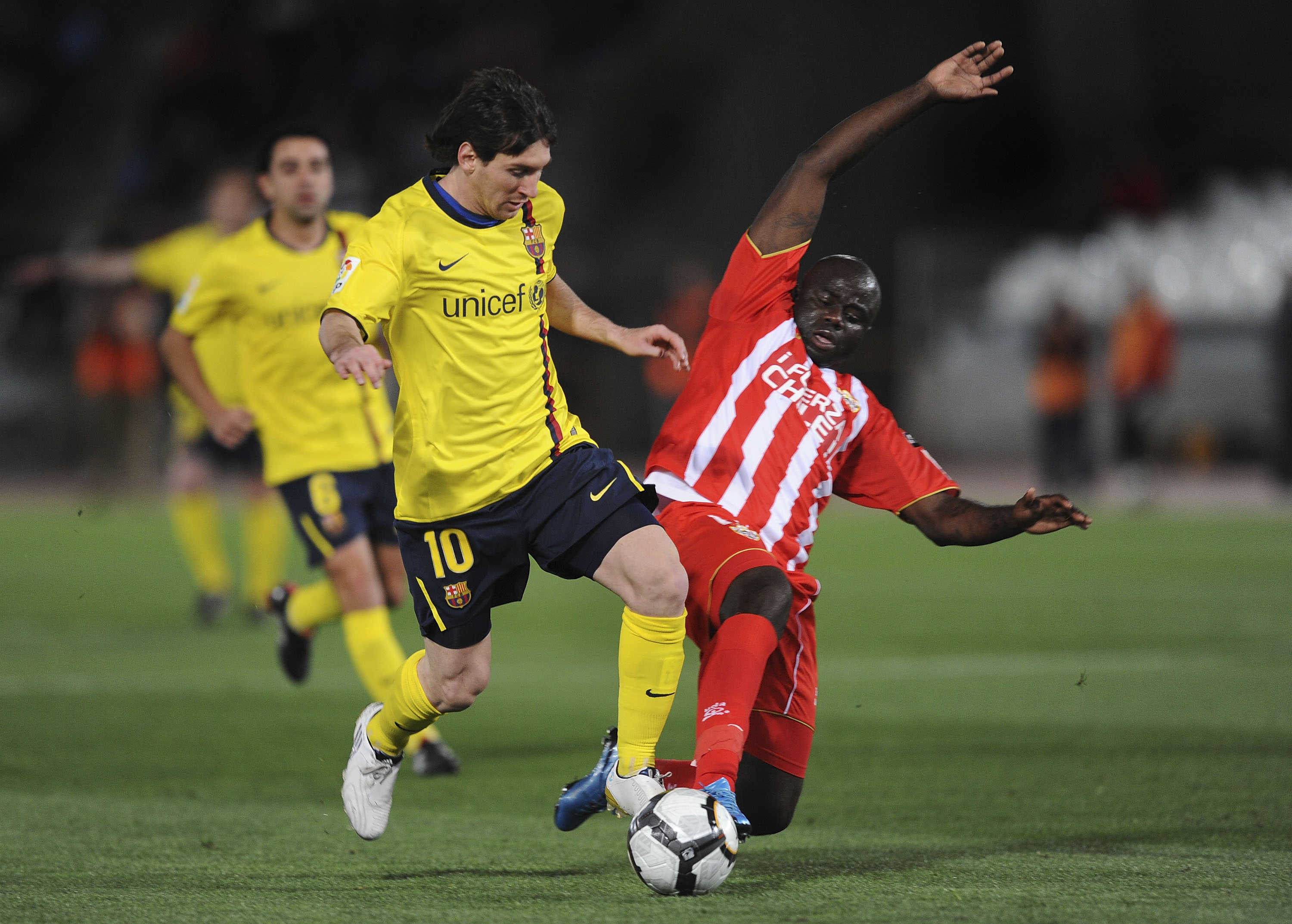 ALMERIA, SPAIN - MARCH 06: Lionel Messi (L) of Barcelona is tackled by Modeste M'bami of UD Almeria during the La Liga match between UD Almeria and Barcelona at Estadio del Mediterraneo on March 6, 2010 in Almeria, Spain.  (Photo by Denis Doyle/Getty Imag