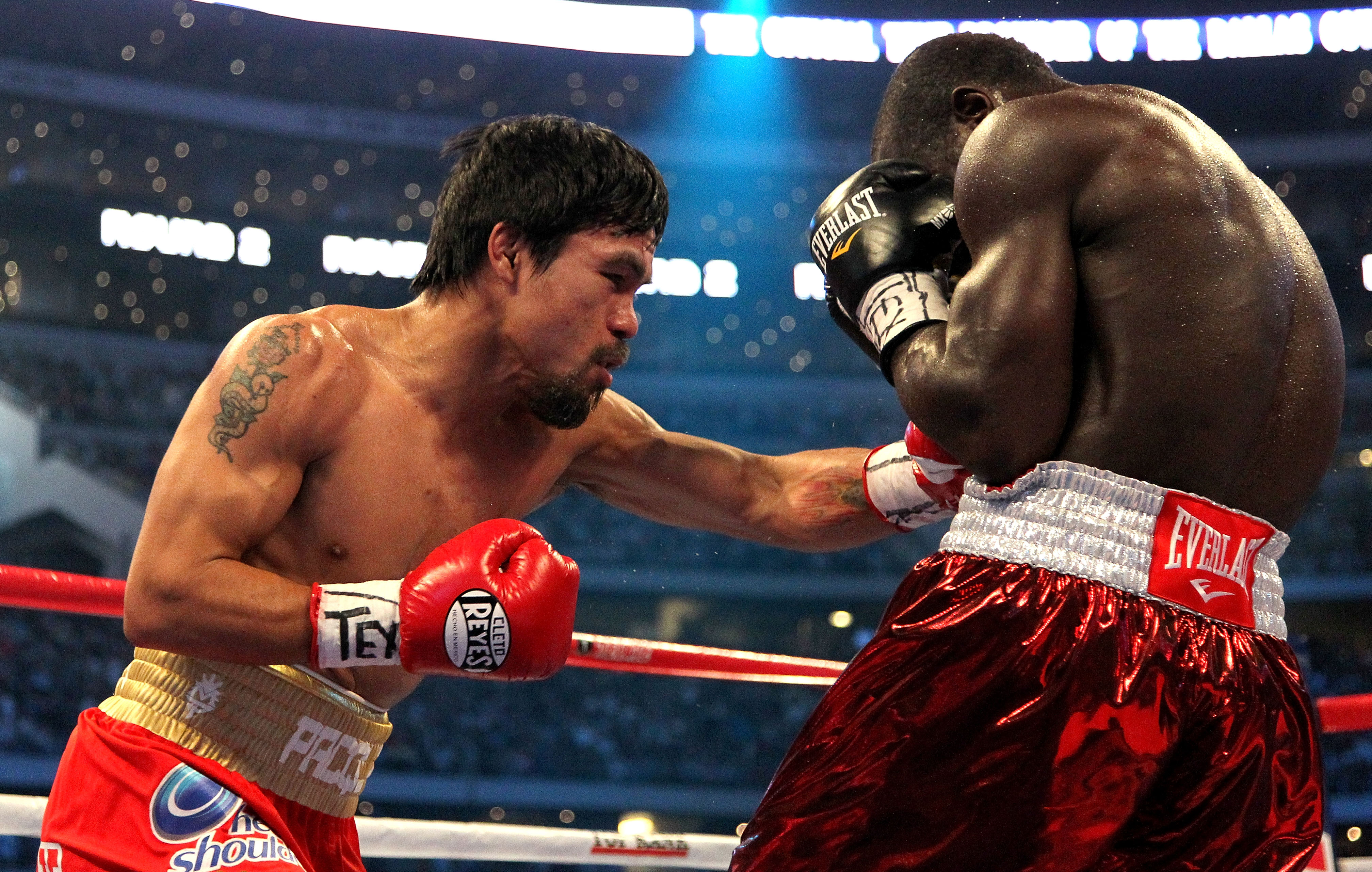 ARLINGTON, TX - MARCH 13:  (L-R) Manny Pacquiao of the Philippines throws a left to the body of Joshua Clottey of Ghana during the WBO welterweight title fight at Cowboys Stadium on March 13, 2010 in Arlington, Texas.  (Photo by Jed Jacobsohn/Getty Images