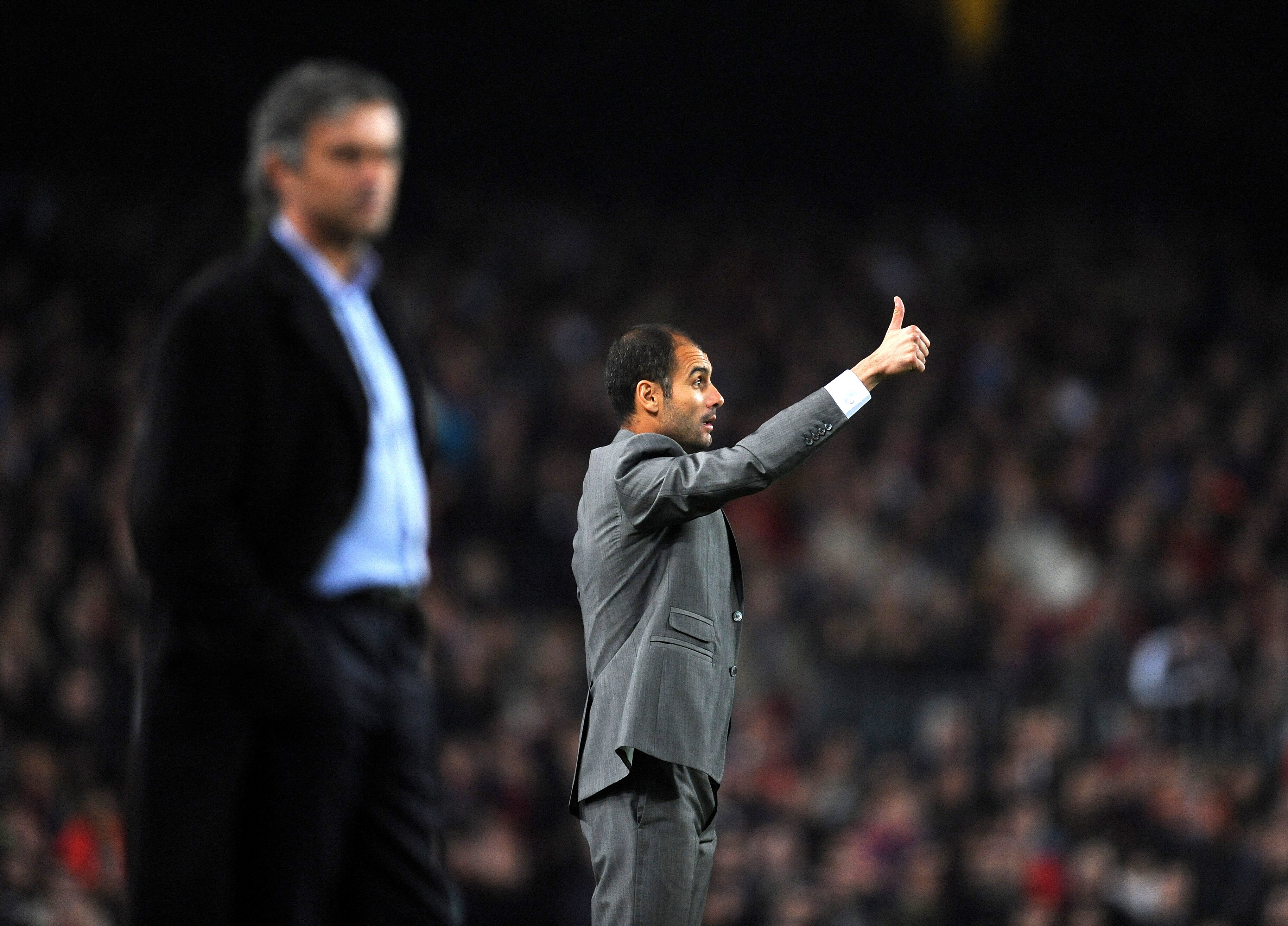 BARCELONA, SPAIN - NOVEMBER 24:  Coach Josep Guardiola (R) of FC Barcelona gestures thumbs up to his players flanked by coach Jose Mourinho of Inter Milan during the UEFA Champions League group F match between FC Barcelona and Inter Milan at the Camp Nou
