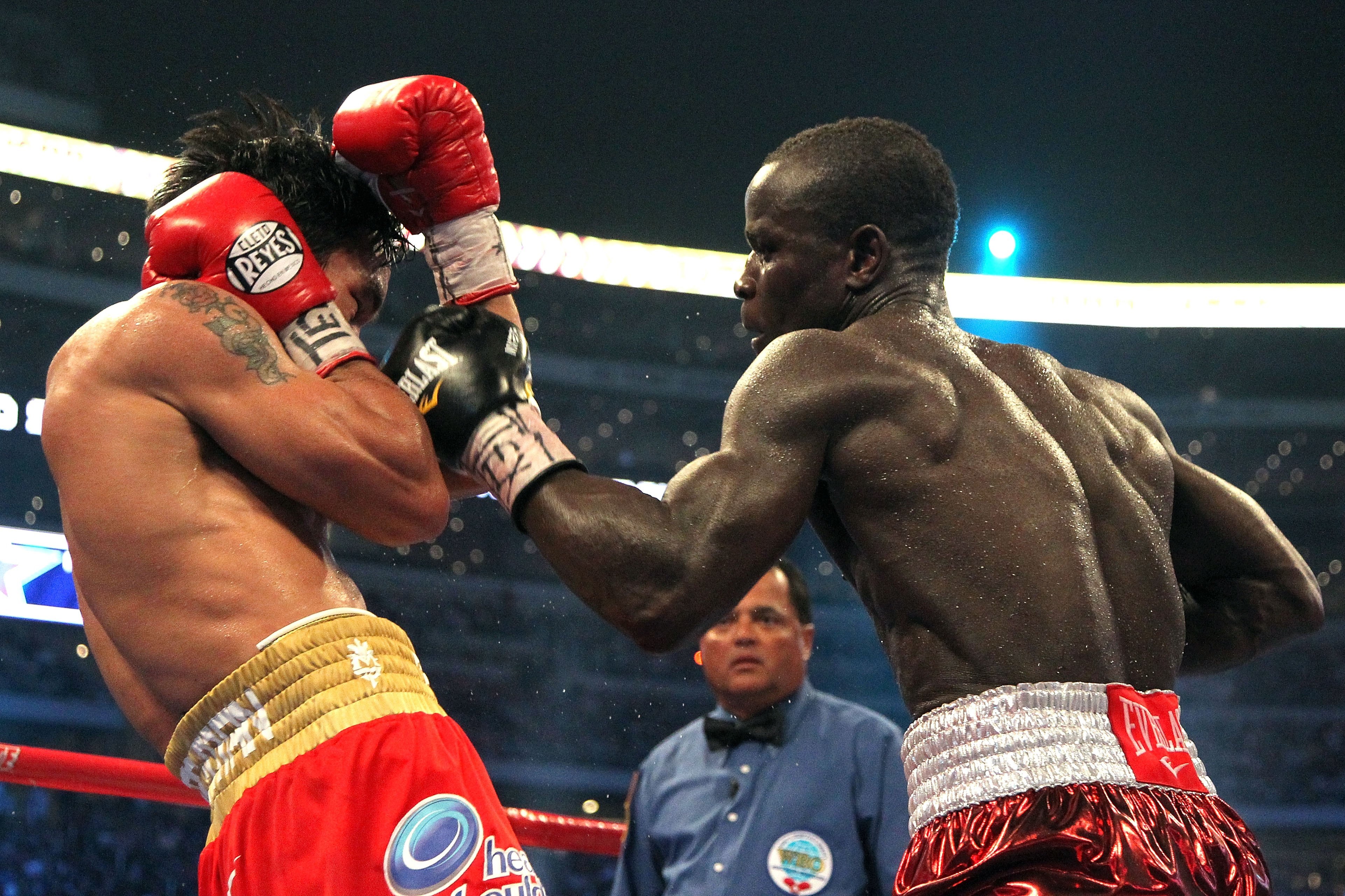 ARLINGTON, TX - MARCH 13:  (R-L) Joshua Clottey of Ghana throws a left to the face of Manny Pacquiao of the Philippines during the WBO welterweight title fight at Cowboys Stadium on March 13, 2010 in Arlington, Texas.  (Photo by Jed Jacobsohn/Getty Images