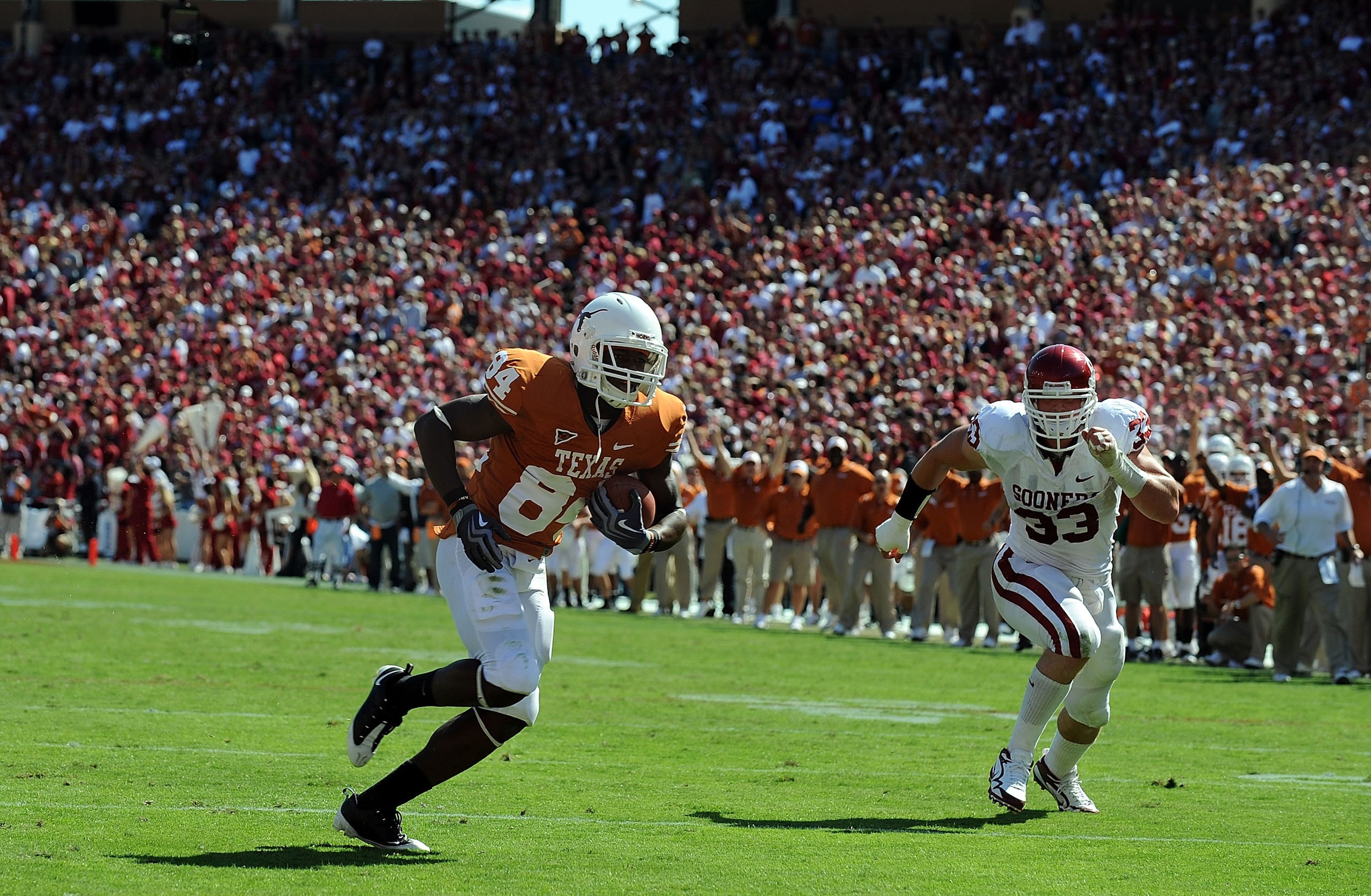 DALLAS - OCTOBER 17:  Wide receiver Marquise Goodwin #84 of the Texas Longhorns runs for a touchdown against Auston English #33 of the Oklahoma Sooners at Cotton Bowl on October 17, 2009 in Dallas, Texas.  (Photo by Ronald Martinez/Getty Images)