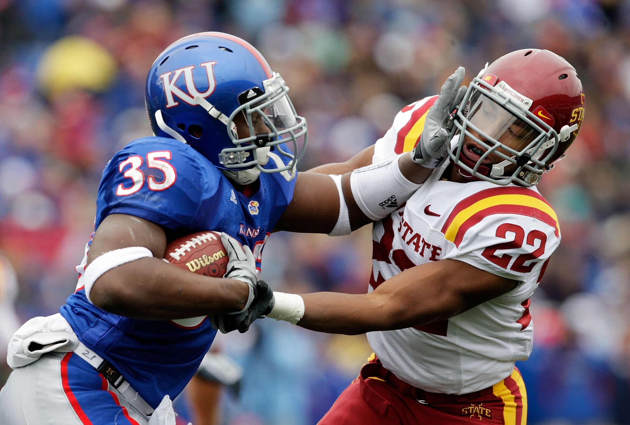 LAWRENCE, KS - OCTOBER 10:  Running back Toben Opurum #35 of the Kansas Jayhawks stiffarms Ter'ran Benton #22 of the Iowa State Cyclones during the game on October 10, 2009 at Memorial Stadium in Lawrence, Kansas.  (Photo by Jamie Squire/Getty Images)