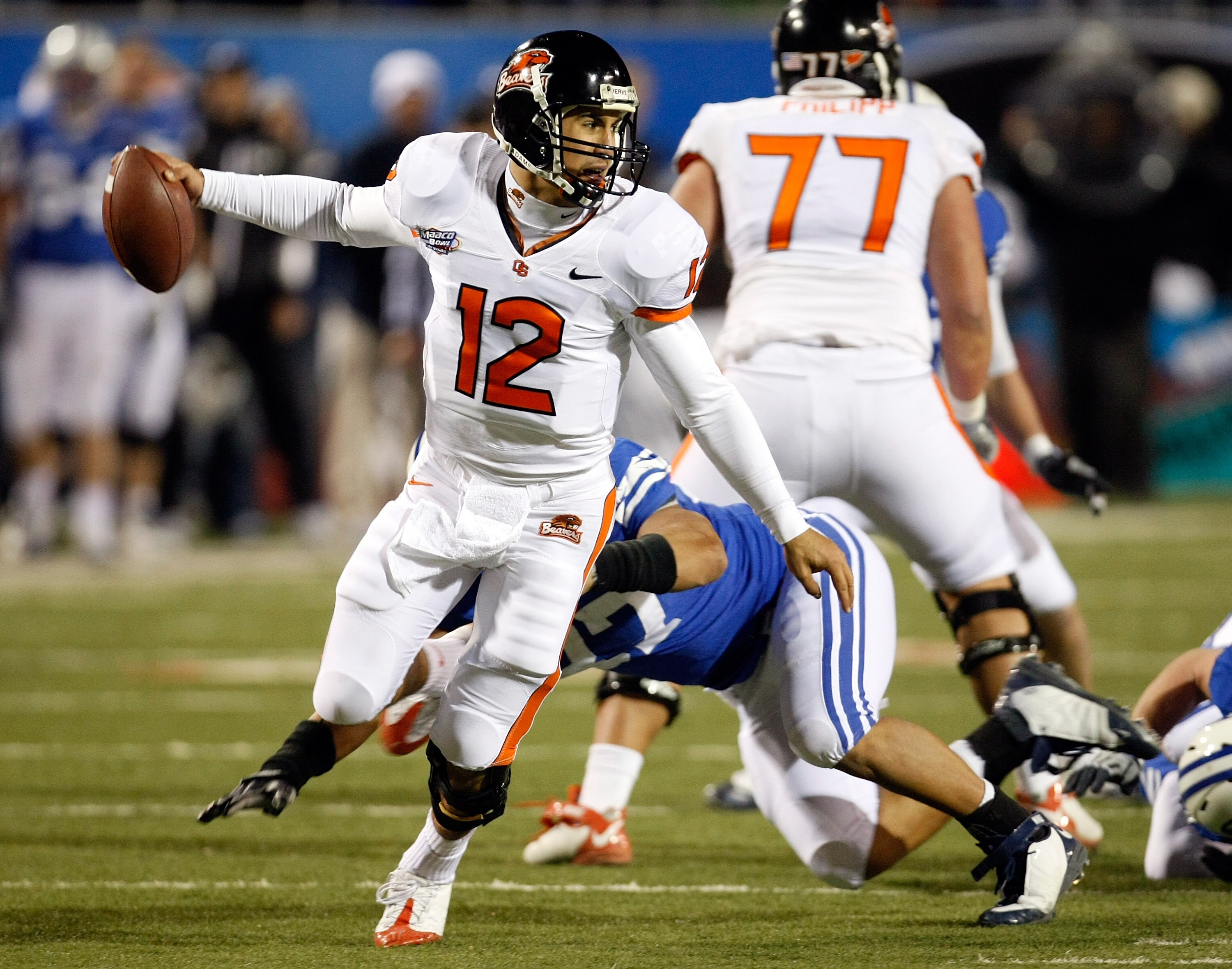 LAS VEGAS - DECEMBER 22:  Quarterback Ryan Katz #12 of the Oregon State Beavers scrambles away from Vic So'oto #37 of the Brigham Young University Cougars during the MAACO Las Vegas Bowl at Sam Boyd Stadium December 22, 2009 in Las Vegas, Nevada. The Coug