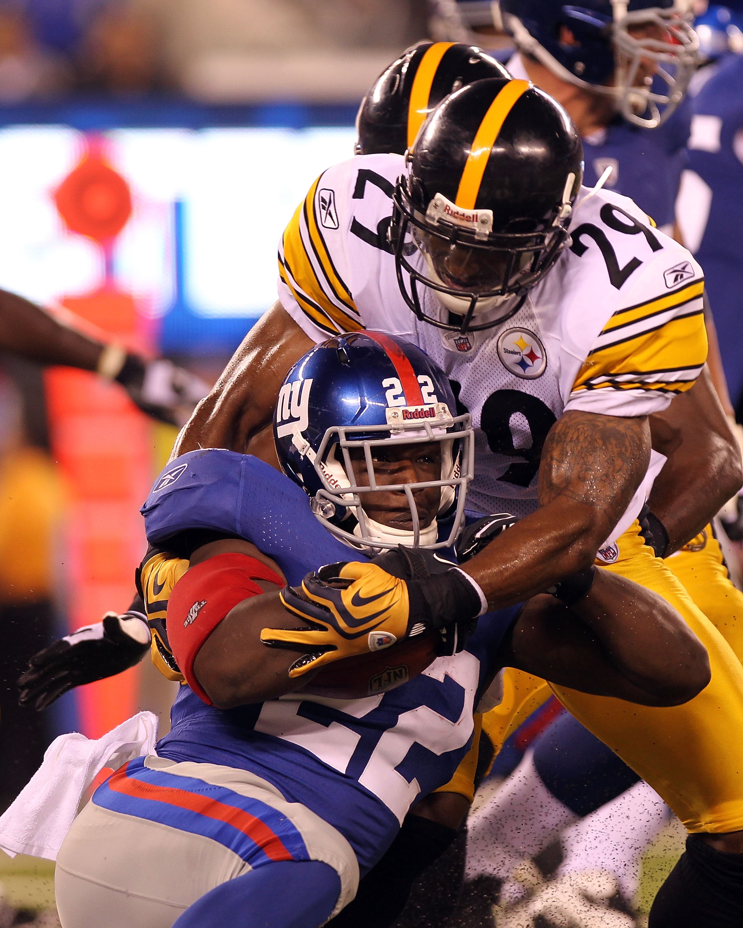 EAST RUTHERFORD, NJ - AUGUST 21: Andre Brown #22 of the New York Giants is tackled by Ryan Mundy #29 of the Pittsburgh Steelers during their preseason game at New Meadowlands Stadium on August 21, 2010 in East Rutherford, New Jersey.  (Photo by Nick Laham
