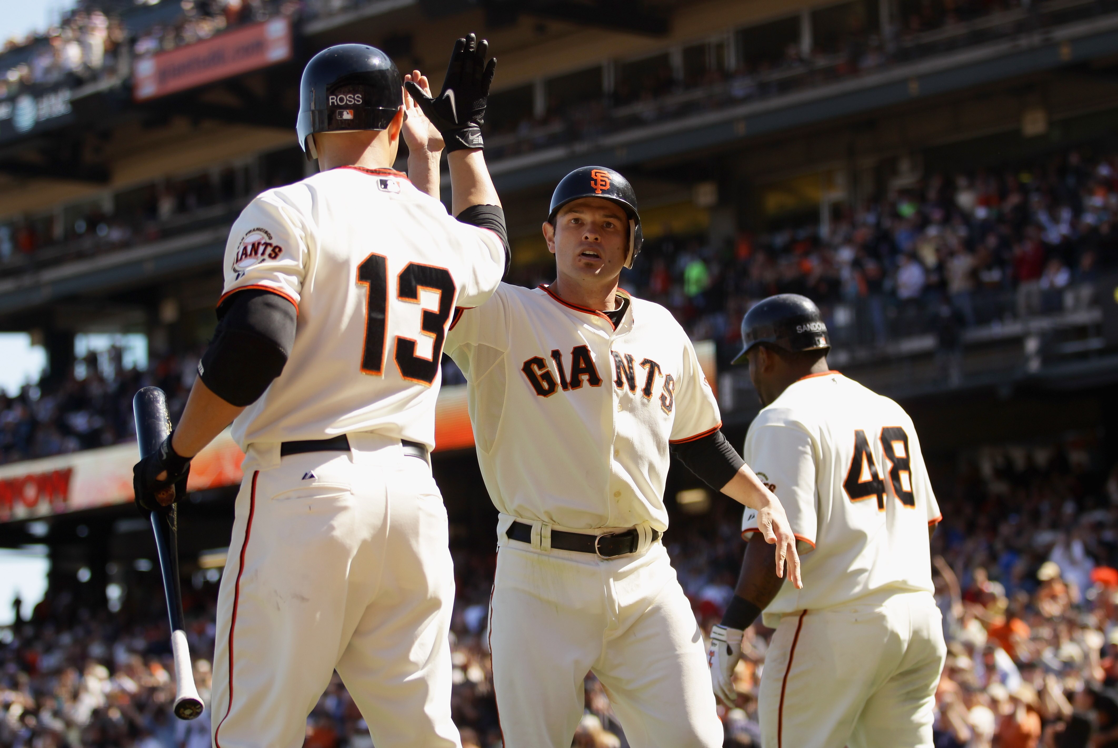 SAN FRANCISCO - AUGUST 29:  Freddy Sanchez #21 of the San Francisco Giants is congratulated by Cody Ross #13 after he scored on a single by Jose Guillen #6 to tie their game 6-6 in the seventh inning of their game against the Arizona Diamondbacks at AT&T