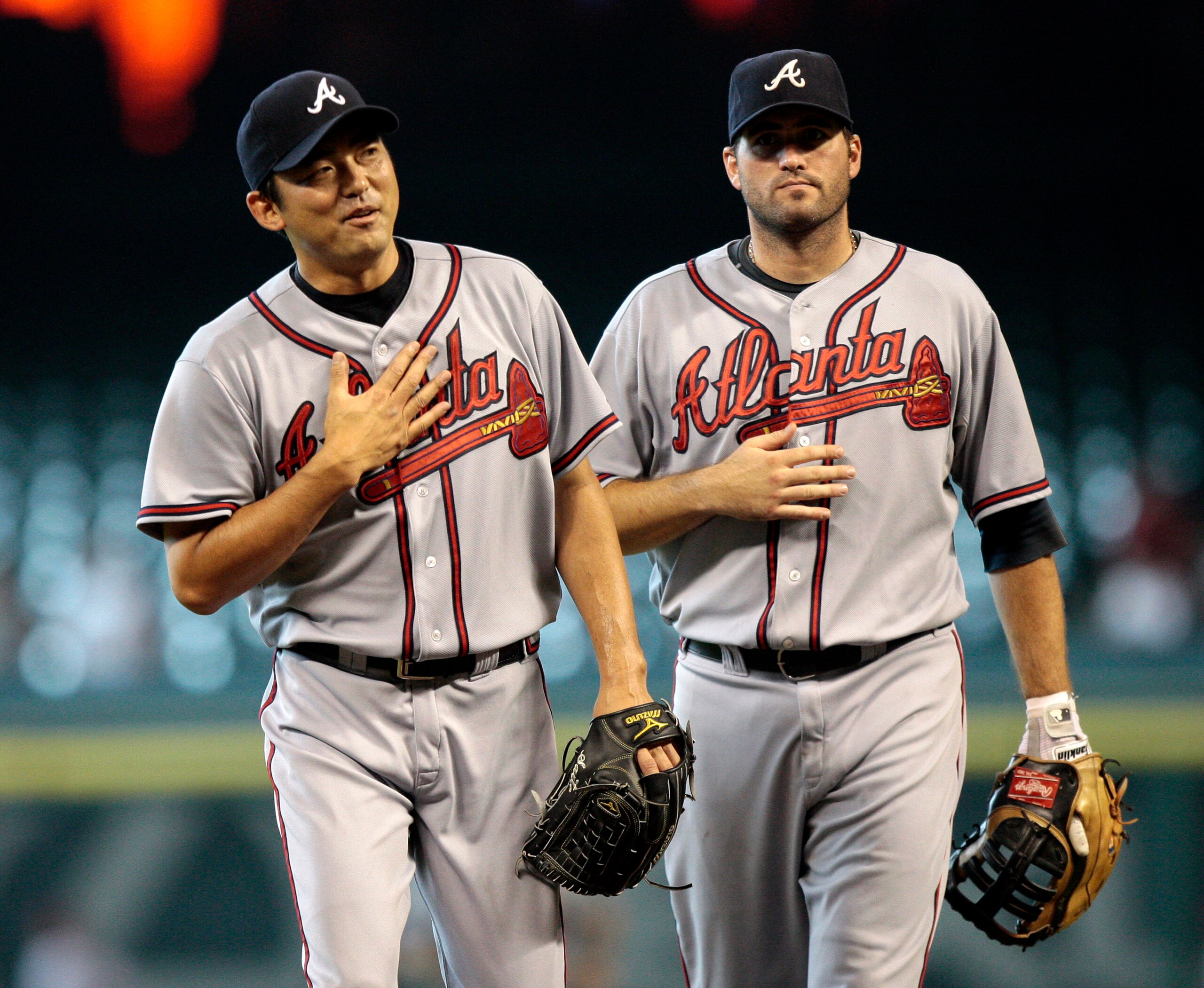 HOUSTON - AUGUST 11:  Pitcher Takashi Saito #40 of Japan, along with Troy Glaus of the Atlanta Braves makes a gesture to his heart after retiring the last hitter in the tenth inning against the Houston Astros at Minute Maid Park on August 11, 2010 in Hous