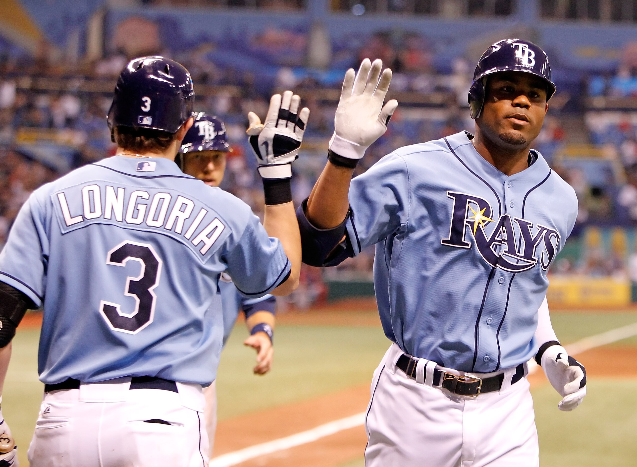 ST. PETERSBURG - AUGUST 29:  Outfielder Carl Crawford #13 (right) of the Tampa Bay Rays is congratulated by Evan Longoria #3 after his home run against the Boston Red Sox during the game at Tropicana Field on August 29, 2010 in St. Petersburg, Florida.  (