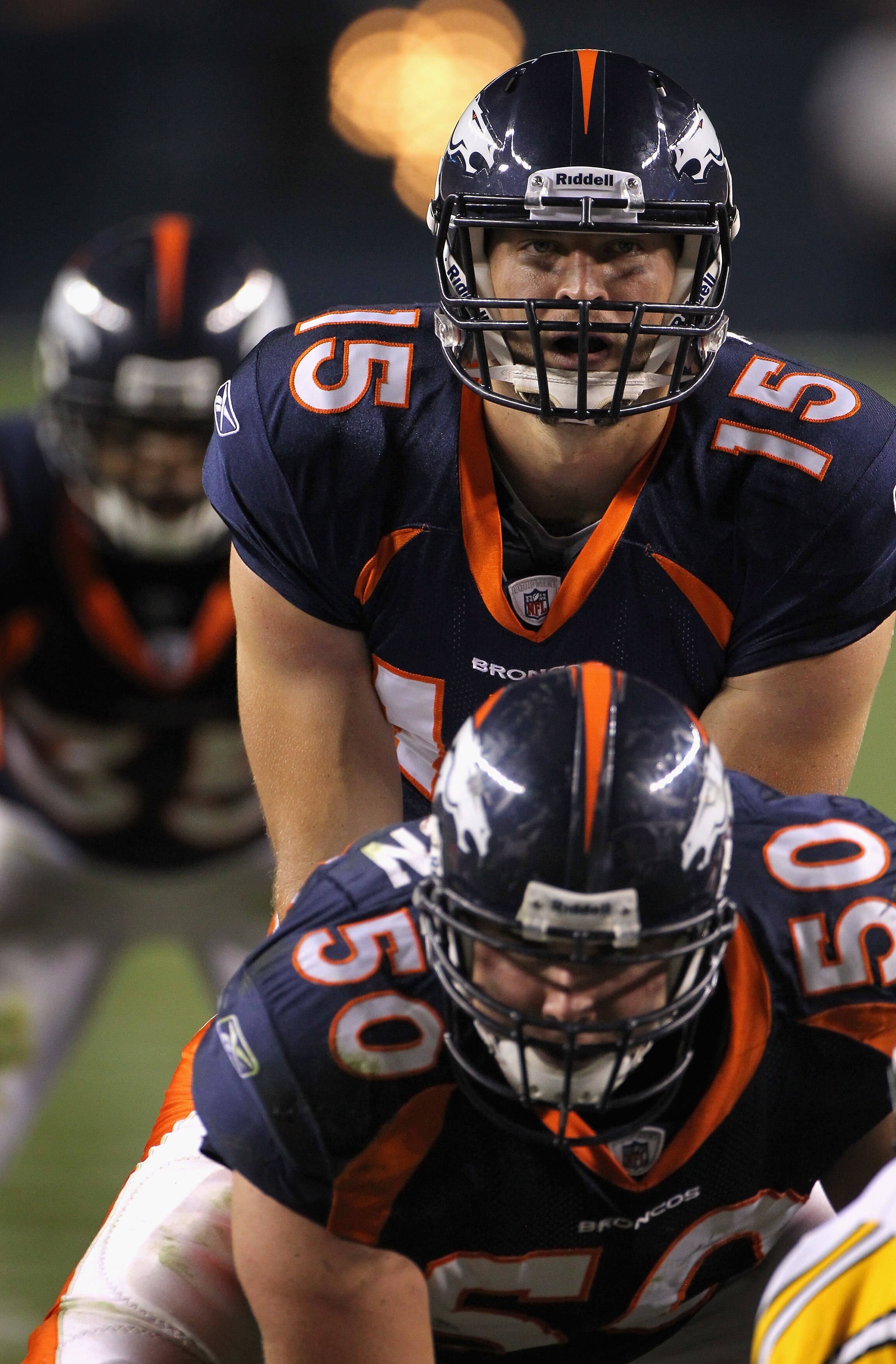 DENVER - AUGUST 29:  Quarterback Tim Tebow #15 of the Denver Broncos lines up over center J.D. Walton #50 and prepares to take the snap against the Pittsburgh Steelers during preseason NFL action at INVESCO Field at Mile High on August 29, 2010 in Denver,